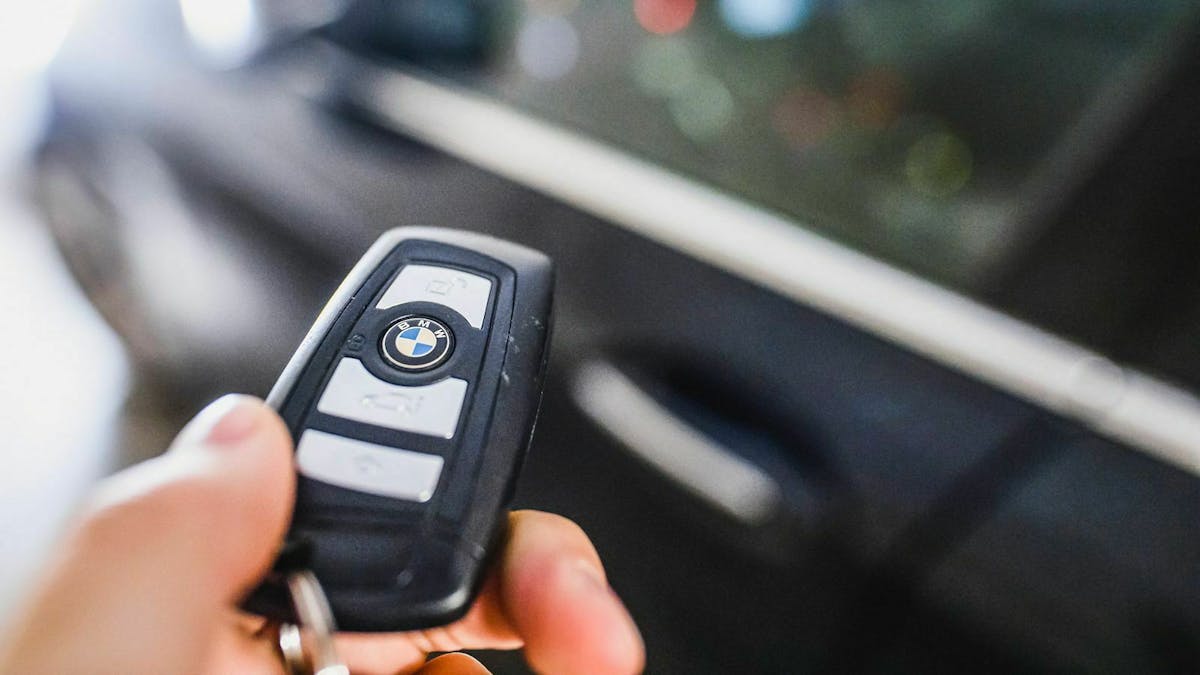 Jemand hält einen Autoschlüssel mit Funkfernbedienung in der Hand.