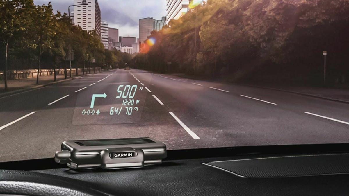 Auf dem Armaturenbrett eines Auto liegt ein nachgerüstetes Head-up-Display, das Fahrdaten in die Windschutzscheibe projiziert.