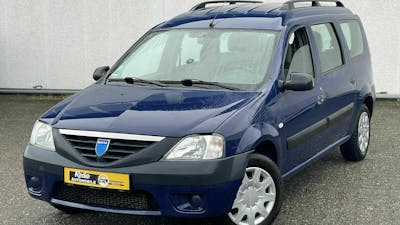 Ein blauer Dacia Logan Kombi steht vor einer weißen Wand