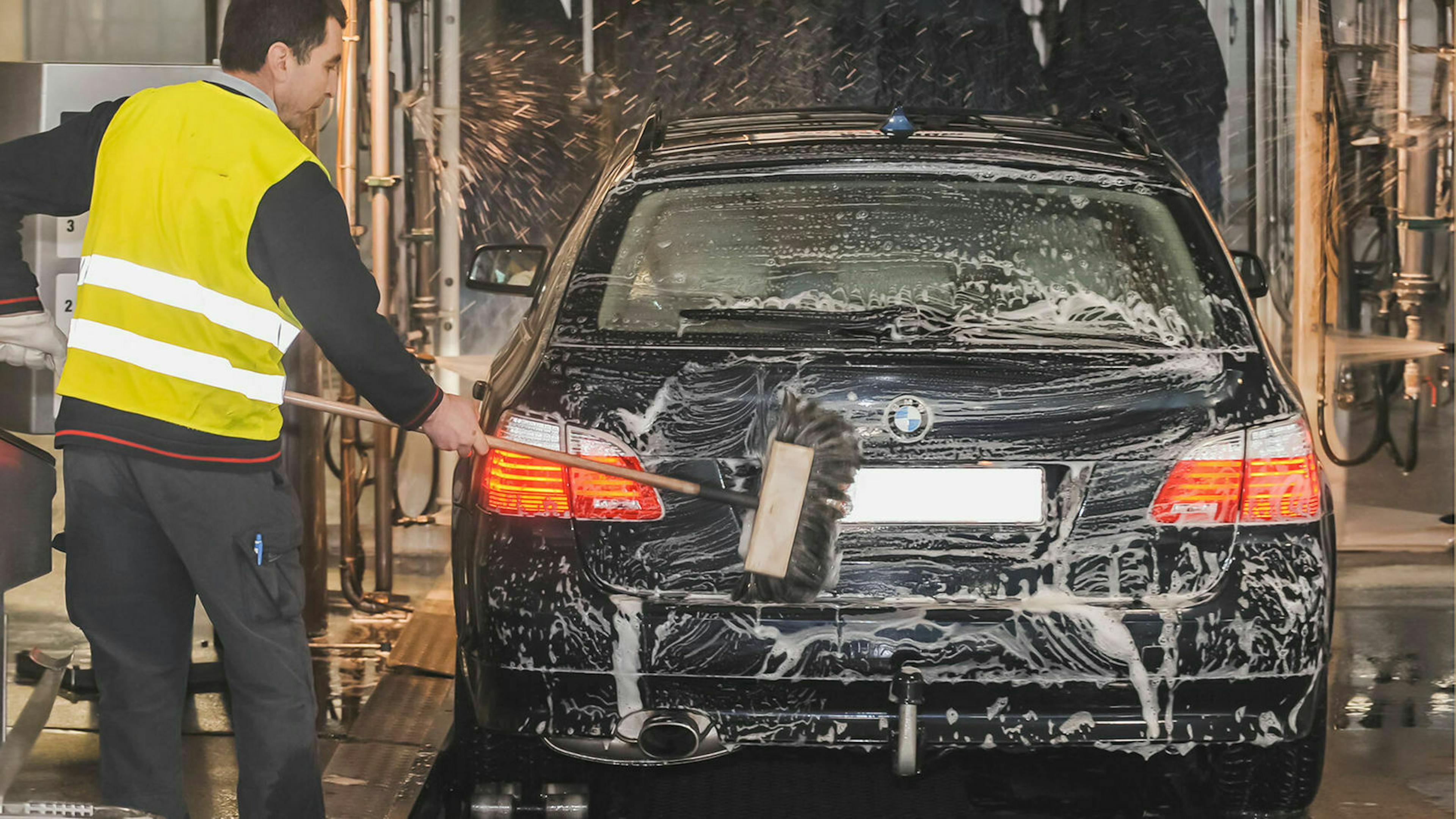 Automatikauto in Waschanlage mit Personal Heckansicht