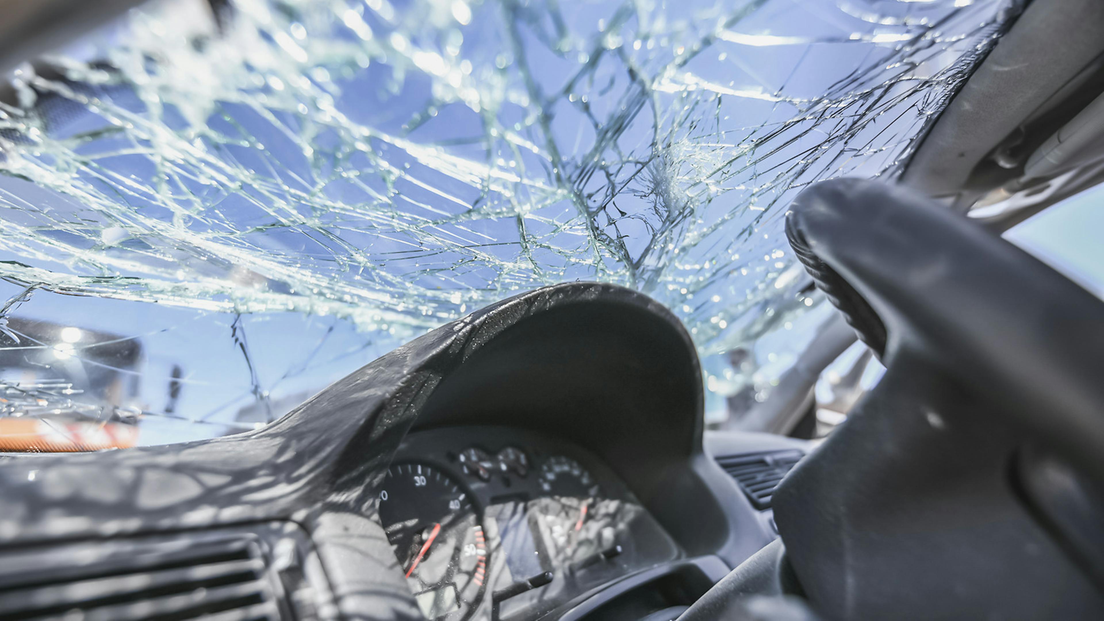 Nach einem Unfall ist die Windschutzscheibe eines Autos gesplittert.