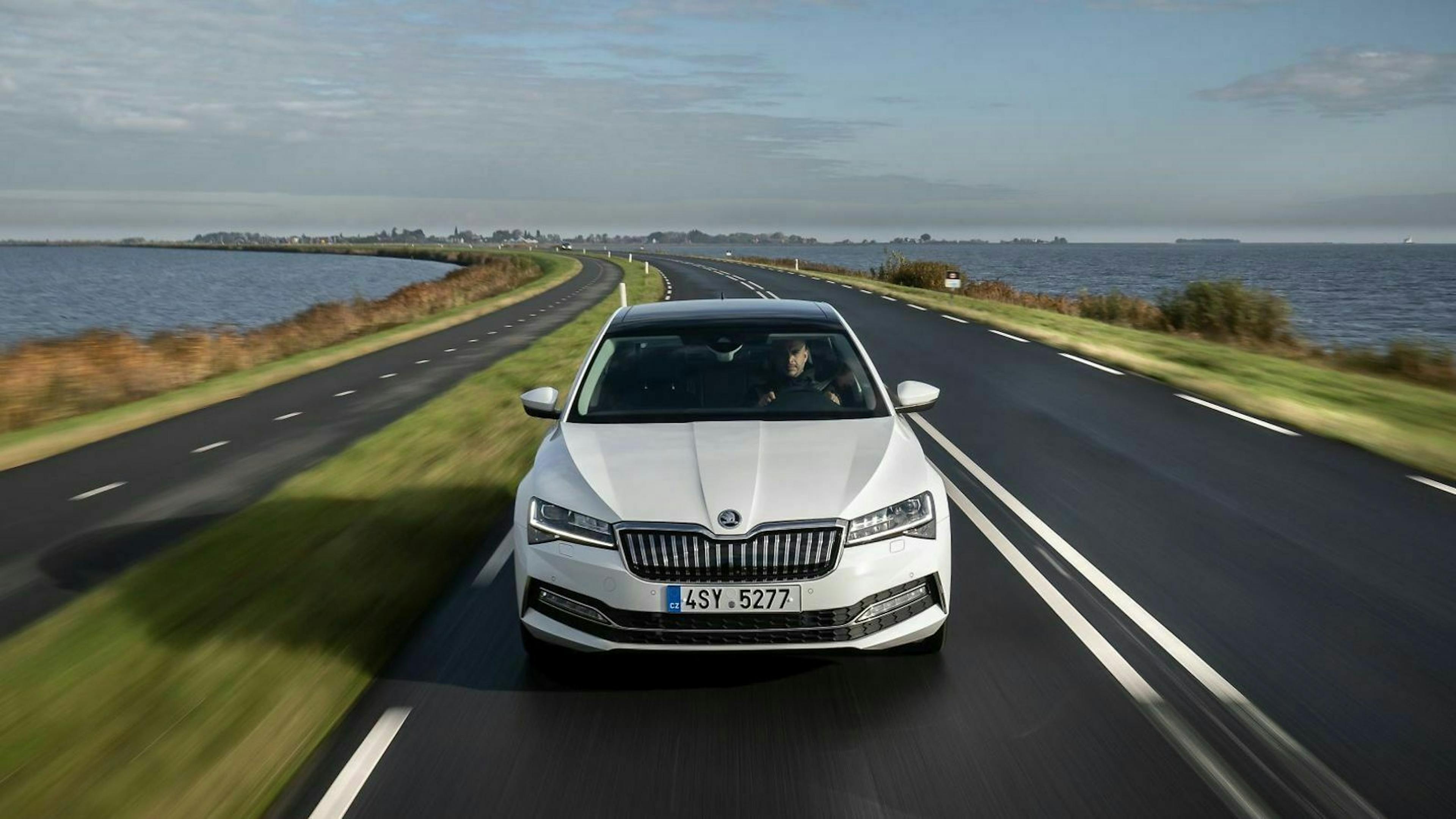 Weißer Škoda Superb in der Frontansicht, fahrend