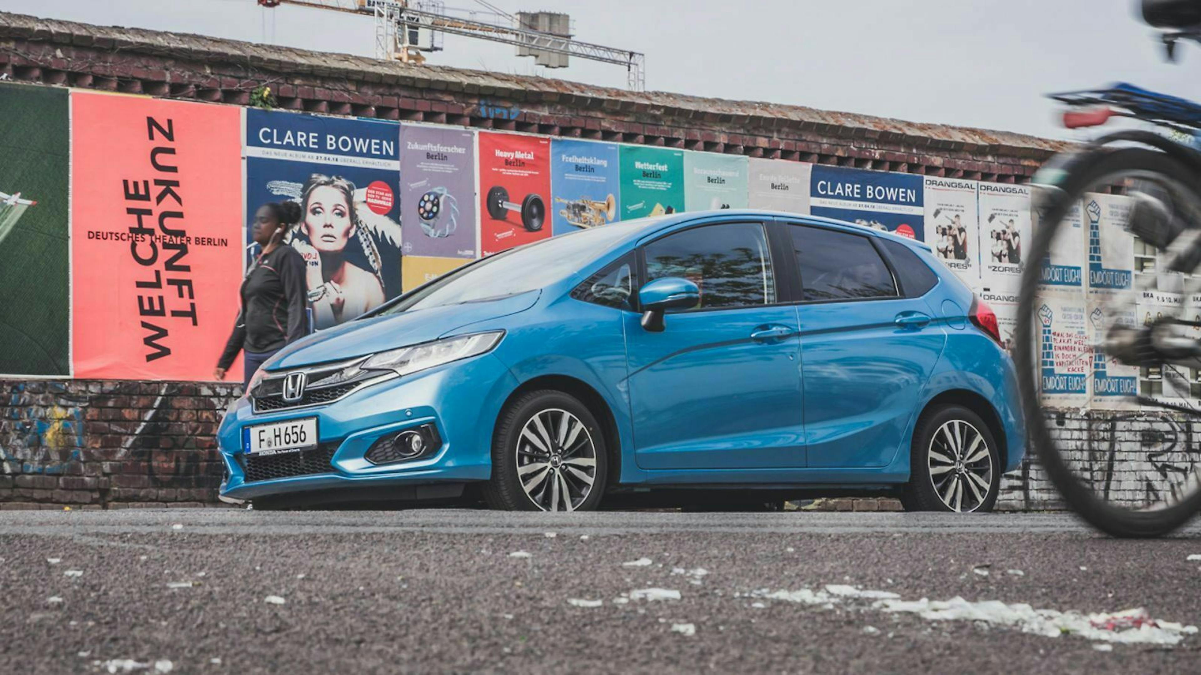 Ein türkisblauer Honda Jazz steht in Berlin in einer Nebenstraße geparkt. 