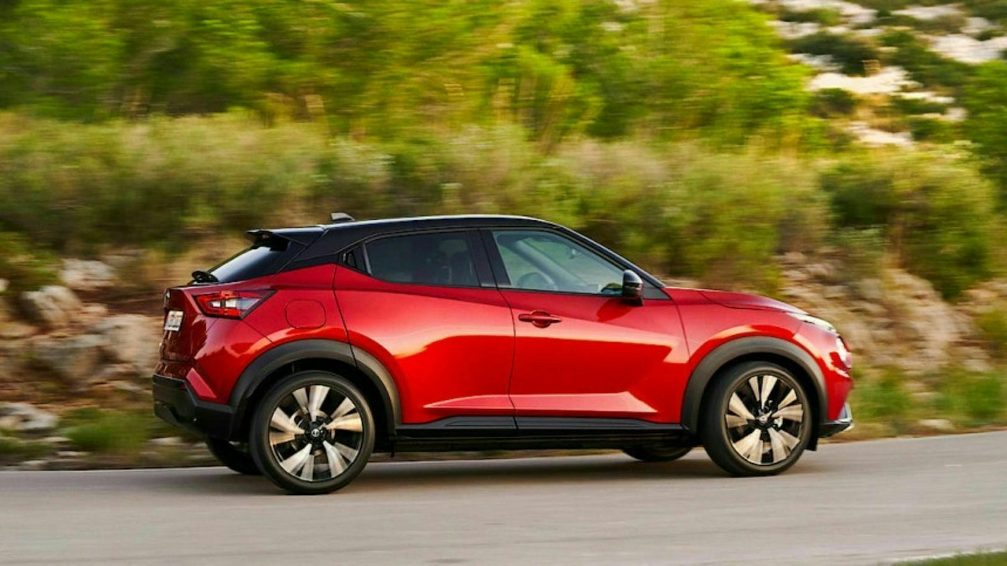 Ein roter Nissan Juke fährt eine Landstraße entlang
