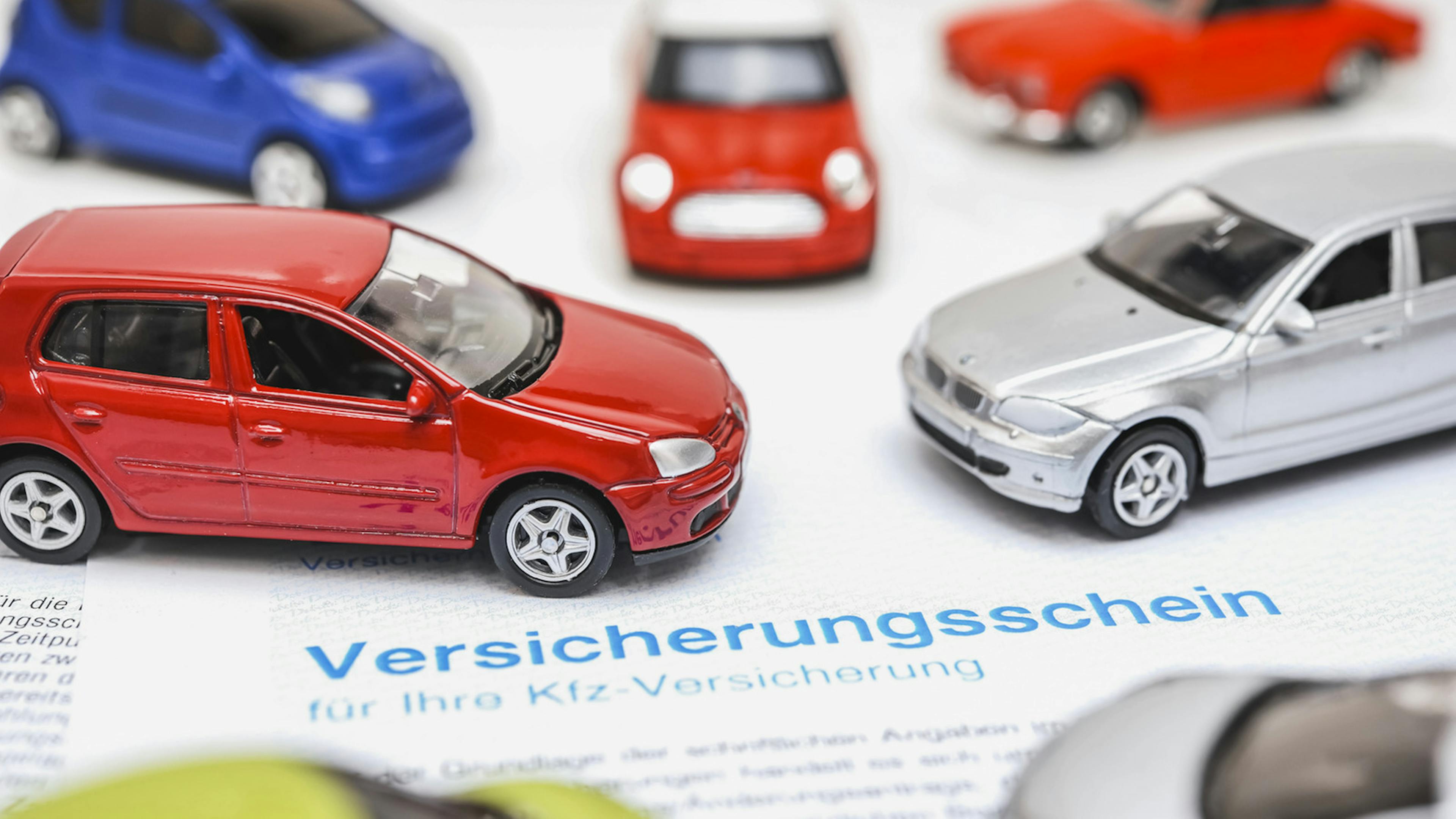 Modellautos stehen auf einem Versicherungsschein.