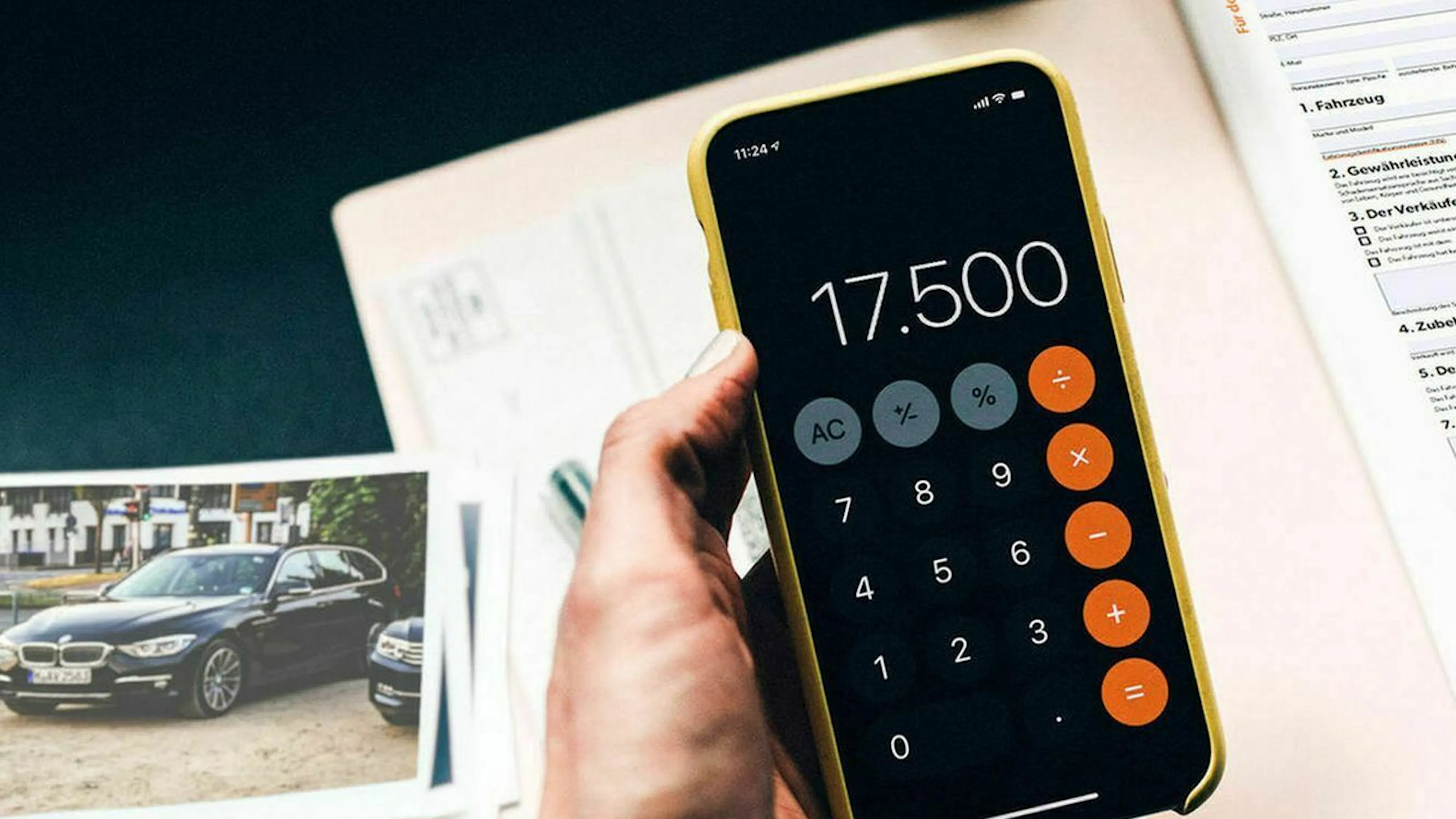 Eine Hand hält ein Smartphone, auf dem ein Taschenrechner aktiviert ist