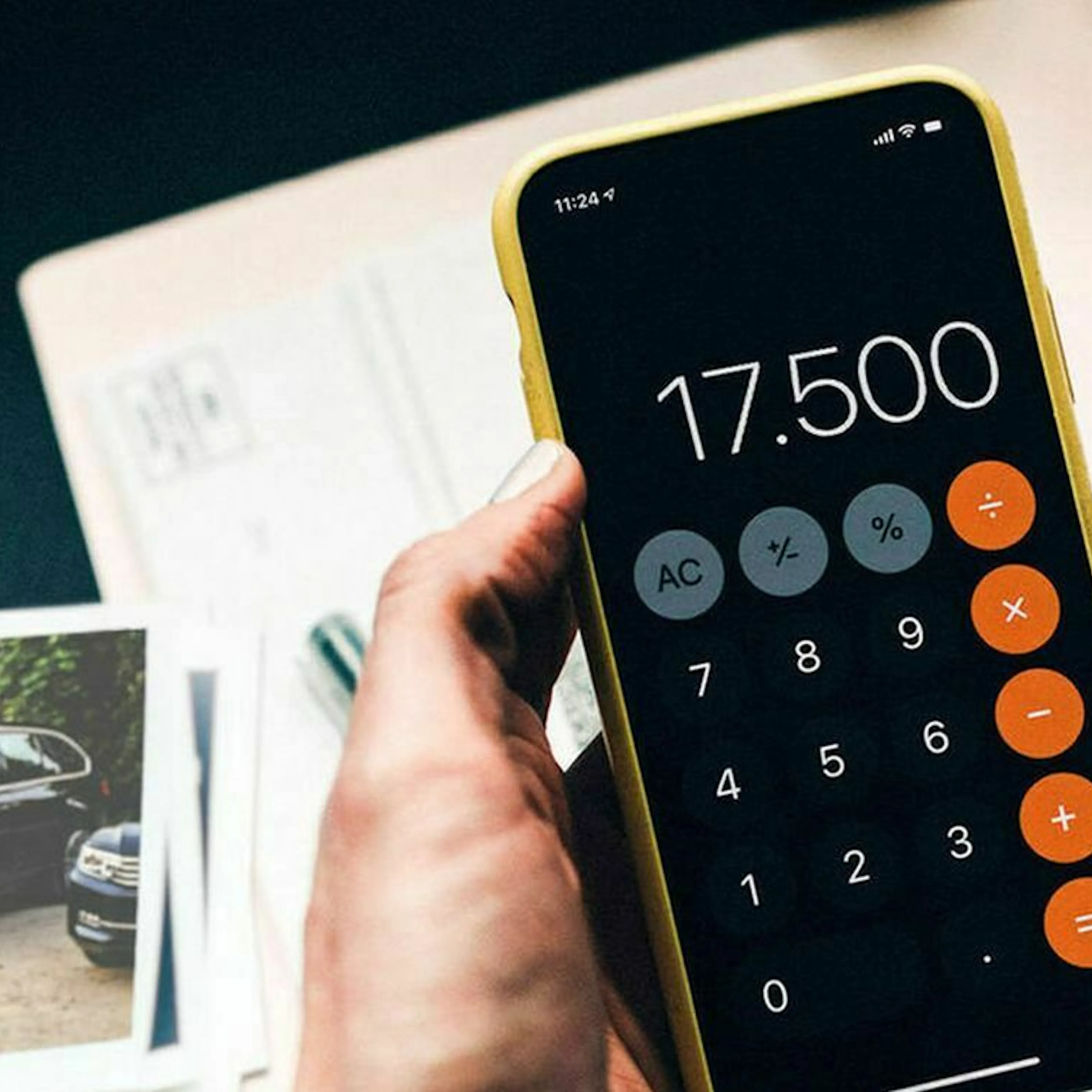 Eine Hand hält ein Smartphone, auf dem ein Taschenrechner aktiviert ist
