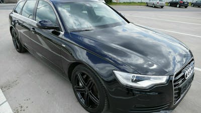 Ein schwarzer Audi A6 mit Panoramadach steht auf einem Parkplatz.