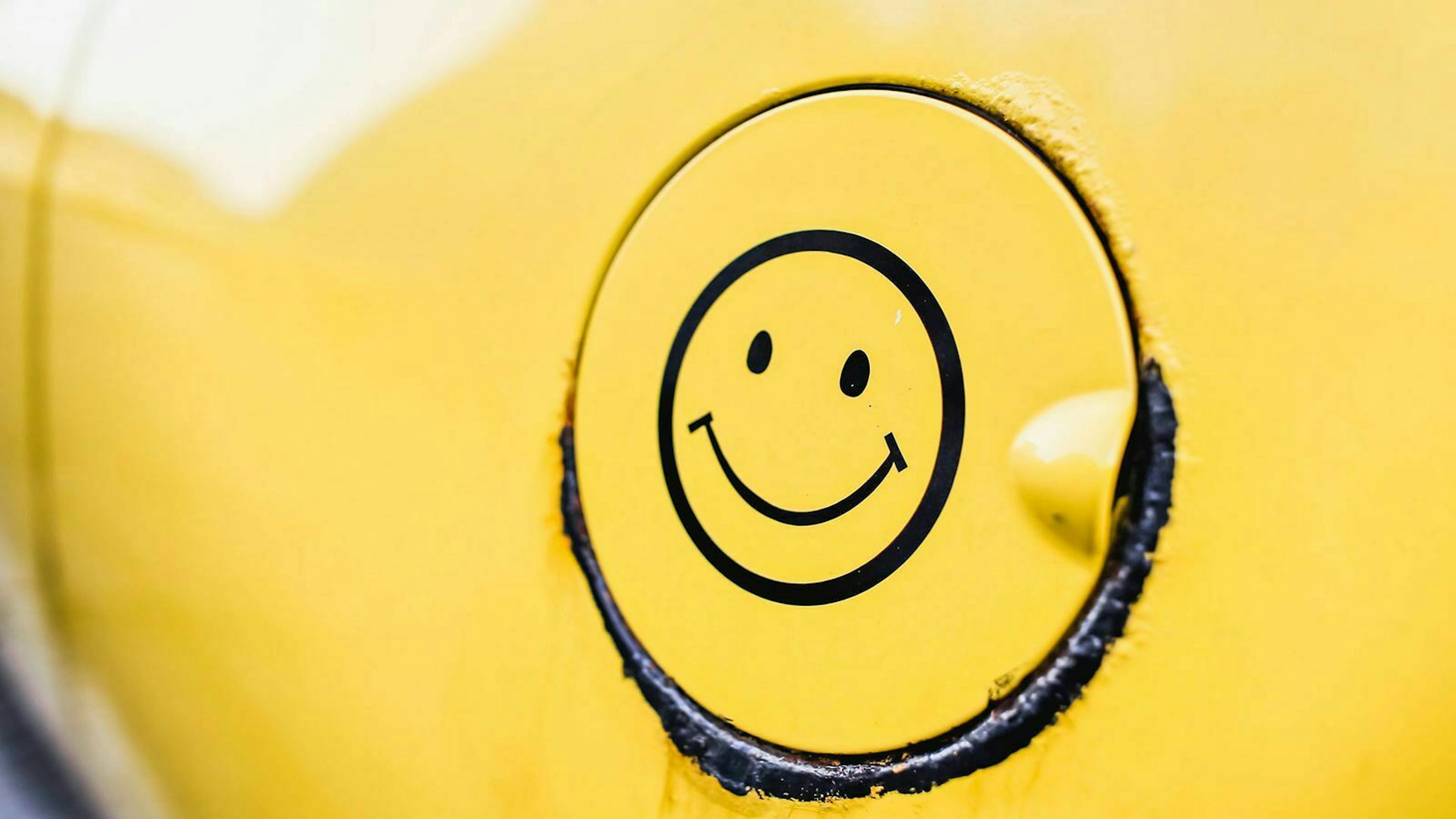 Ein schwarzer Smiley-Aufkleber ist auf einen Tankdeckel geklebt. 