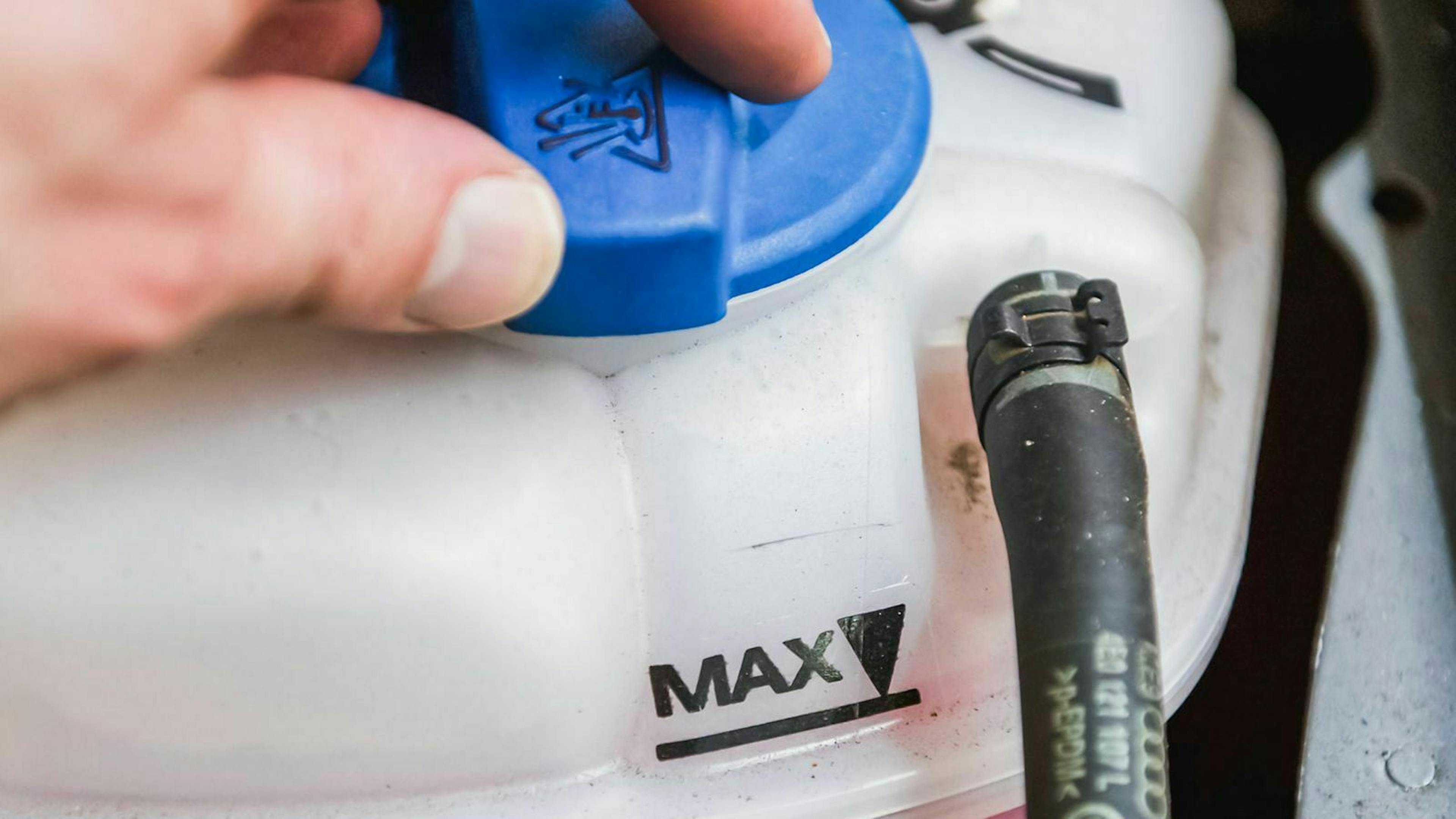 Der Ausgleichsbehälter der Kühlflüssigkeit in einem Auto mit Verbrennungsmotor ist meist mit einem blauen Deckel gekennzeichnet.