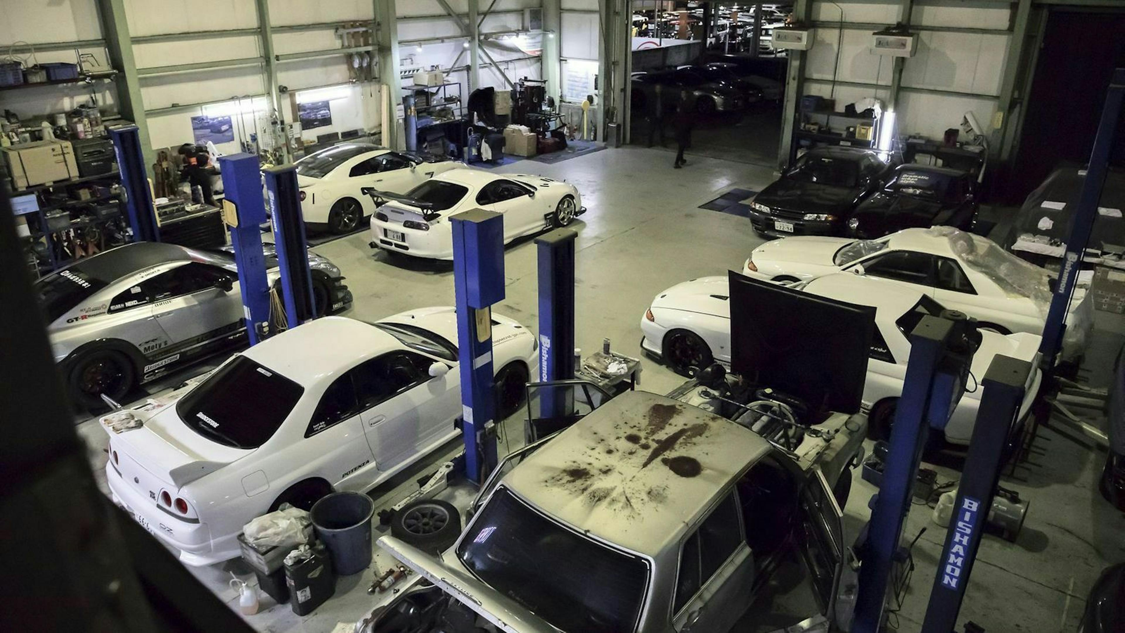 Zu sehen sind mehrere Nissan Skyline Fahrzeuge in der Werkstatt von Kazuhiko Nagata