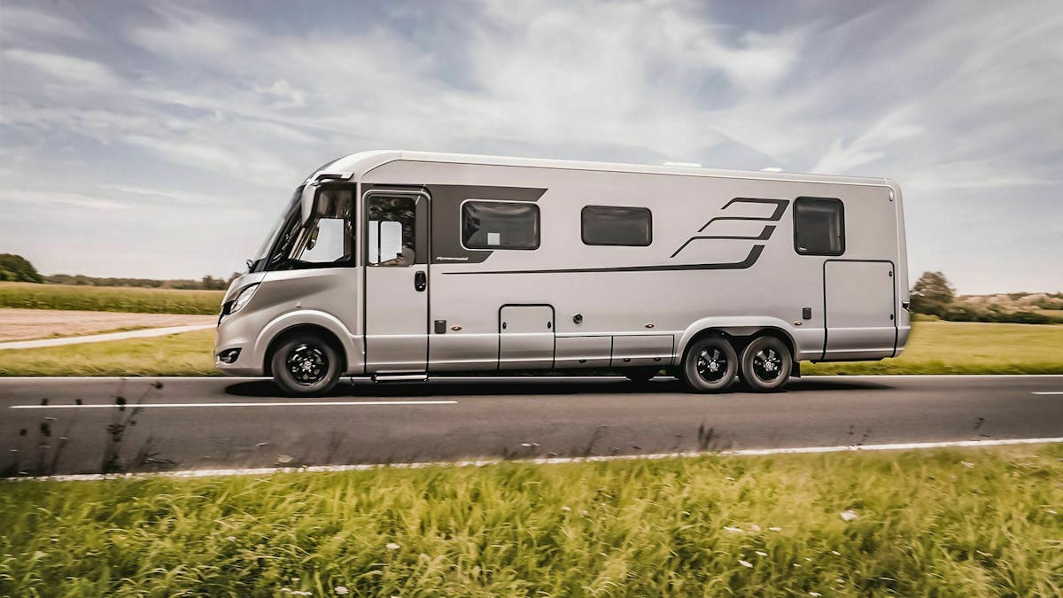 Ein graues wohnmobil vom typ Hymer B-Klasse Masterline fährt über eine Landstraße.