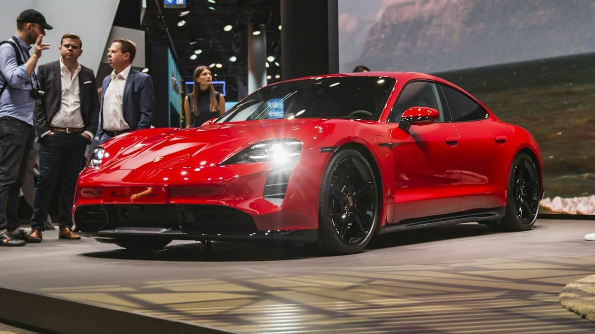 Das Bild zeigt ein rotes Exemplar des Elektro-Sportwagens Porsche Taycan