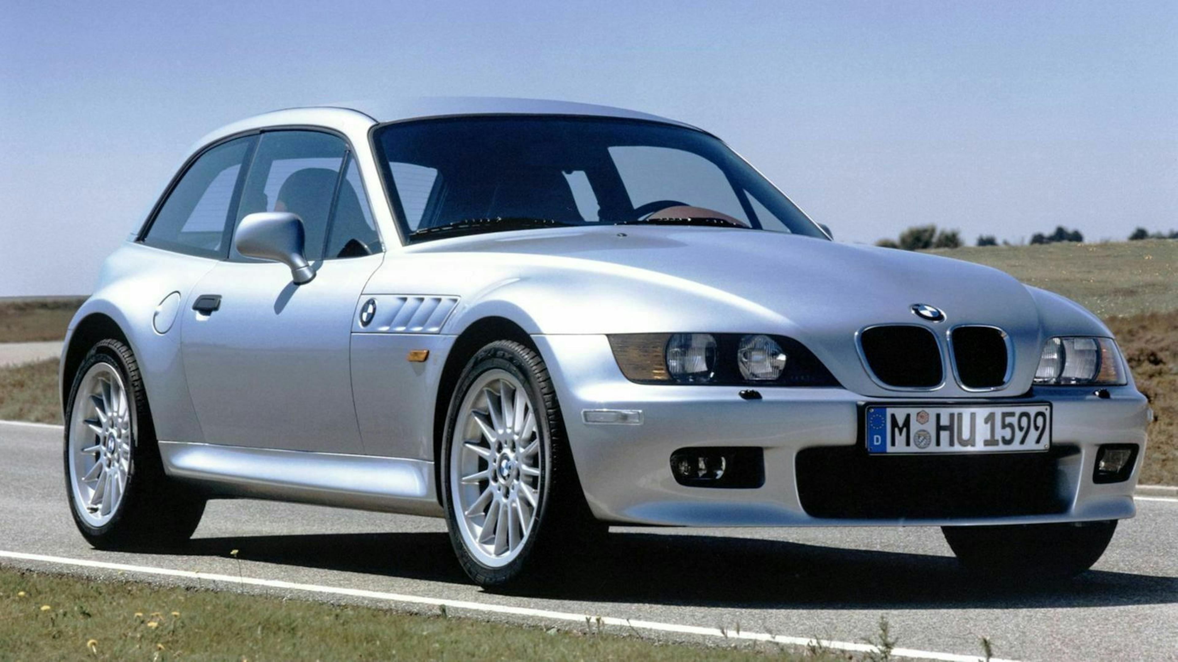 Ein silberner BMW Z3 2.8 Coupé Oldtimer steht am Straßenrand einer Landstraße. 