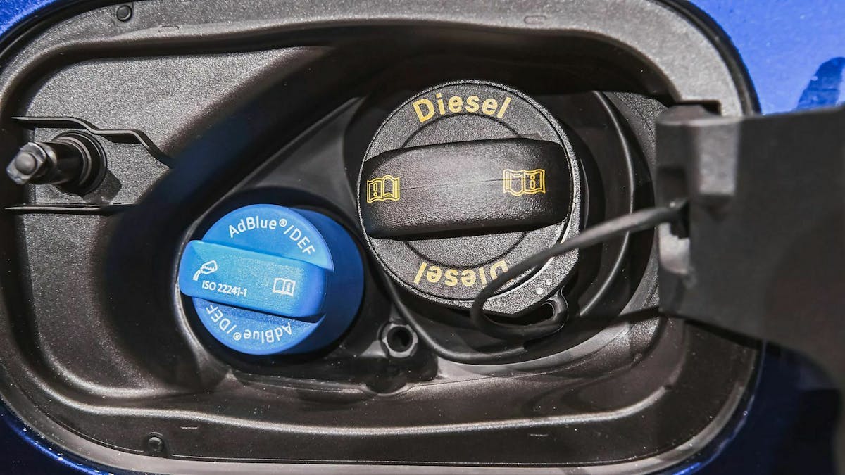 Hinter einer geöffneten Tankklappe sind zwei Deckel für die Einfüllstutzen von Ad-Blue und Diesel zu sehen.