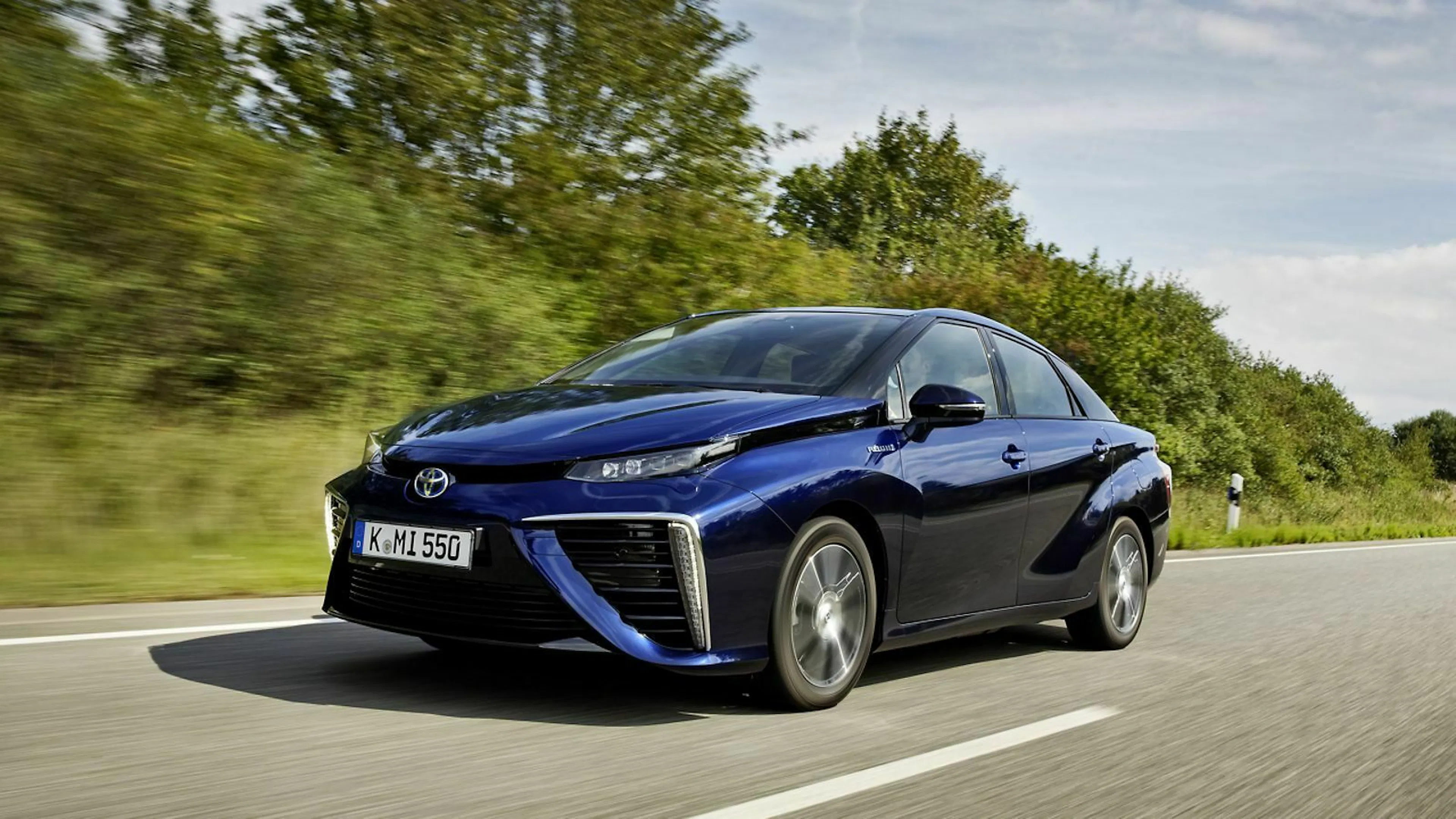 Man sieht einen Toyota Mirai fahrend auf einer Landstraße
