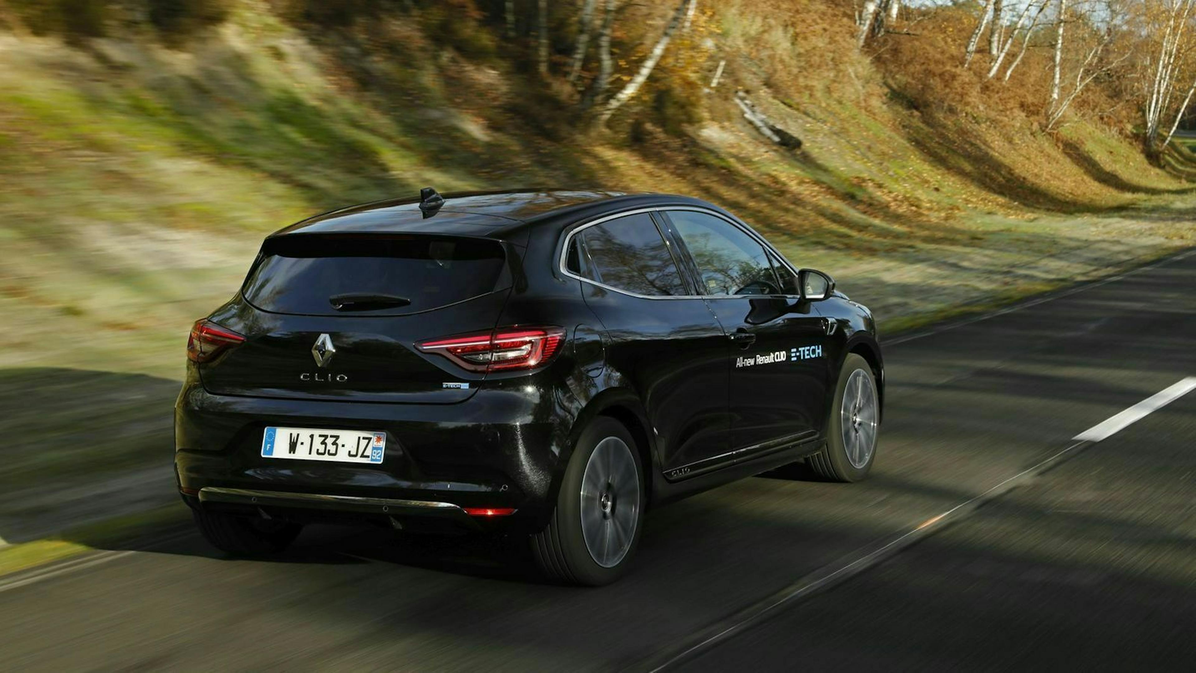 Zu sehen ist der Renault Clio e-Tech Hybrid von hinten, fahrend