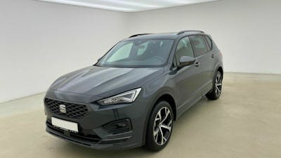 Ein schwarzer Seat Tarraco steht in einem Raum vor einer weißen Wand