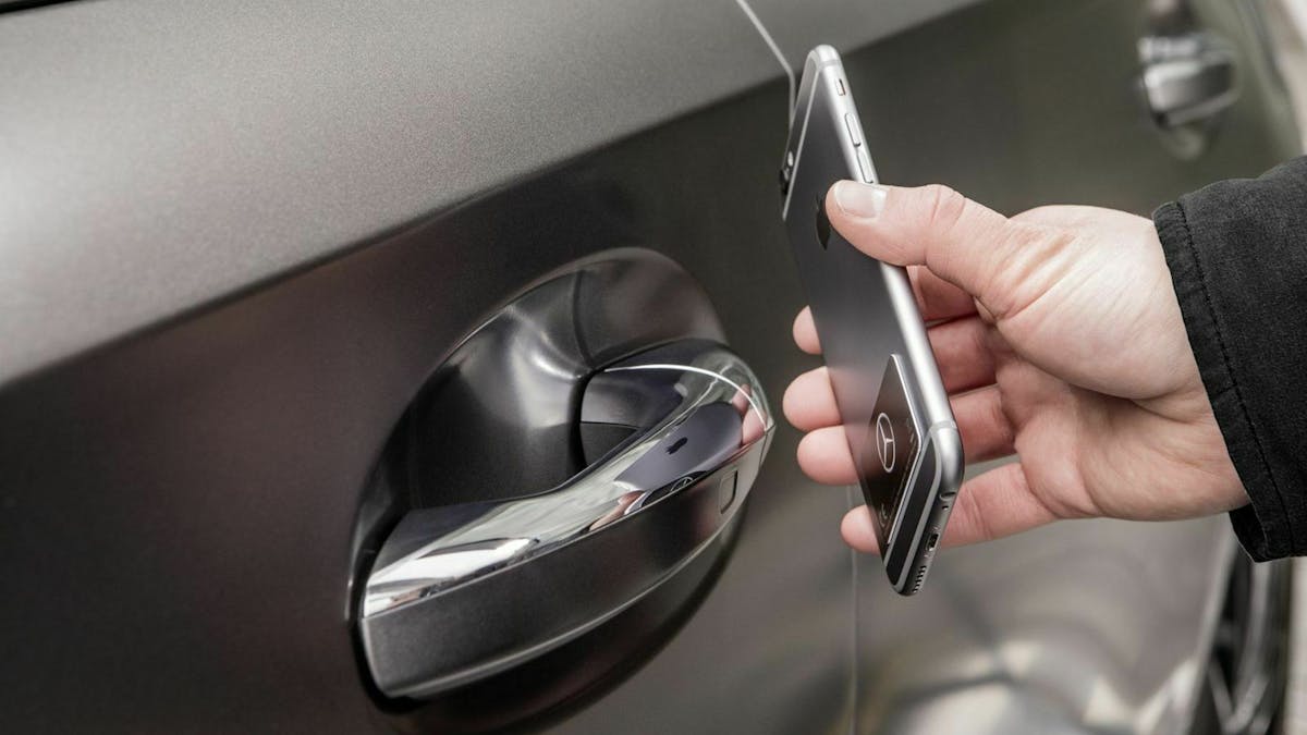 Zu sehen ist ein Mann, der sein Auto mithilfe der NFC - Technologie öffnet