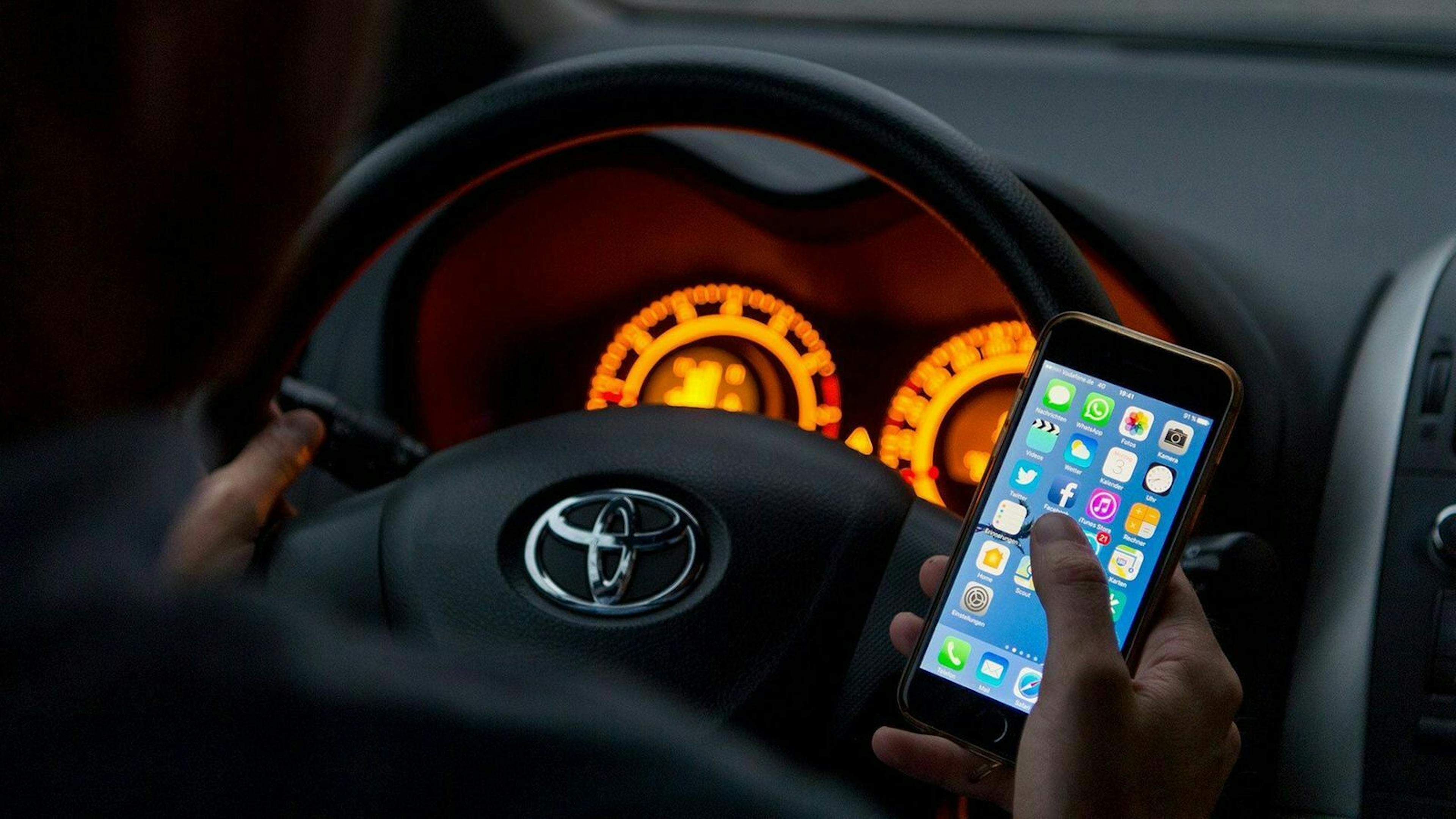 Autofahrer mit einem Smartphone am Steuer