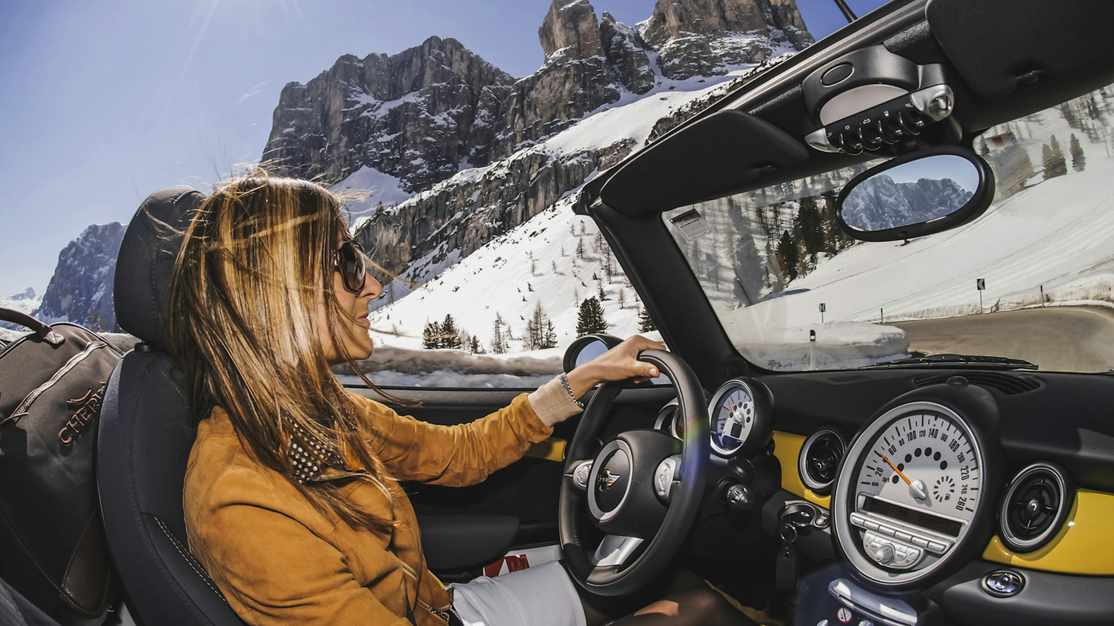 Frau am Steuer eines Mini -Cabrios.