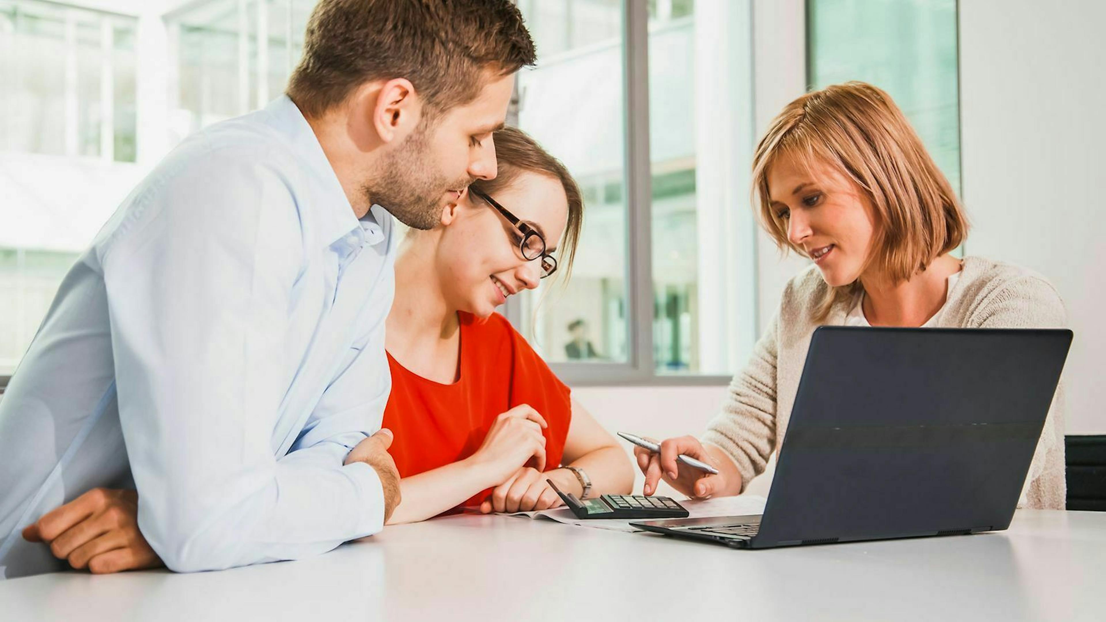 Zwei Kunden lassen sich von einer Versicherungsmaklerin beraten.