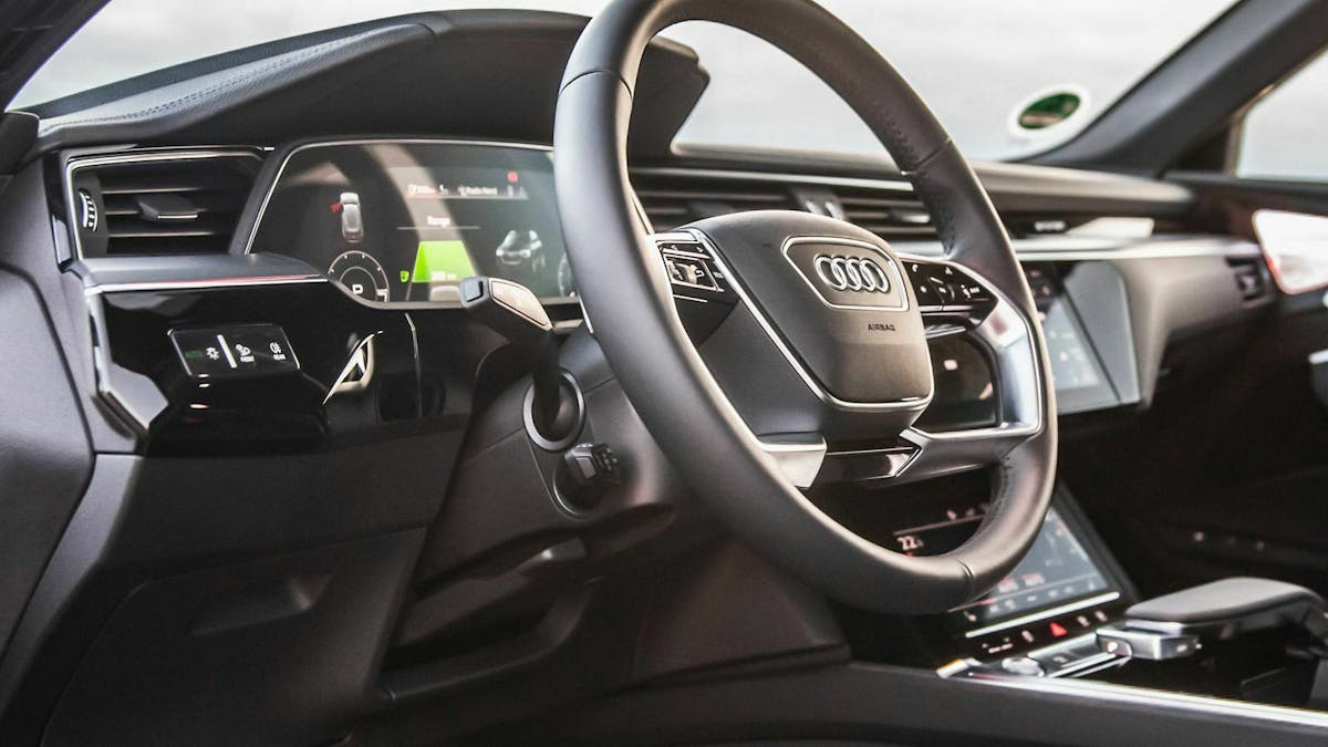 In einem Audi-Cockpit ist der Bedienhebel für den Tempomat unterhalb des Lenkstockhebels für den Blinker zu sehen.