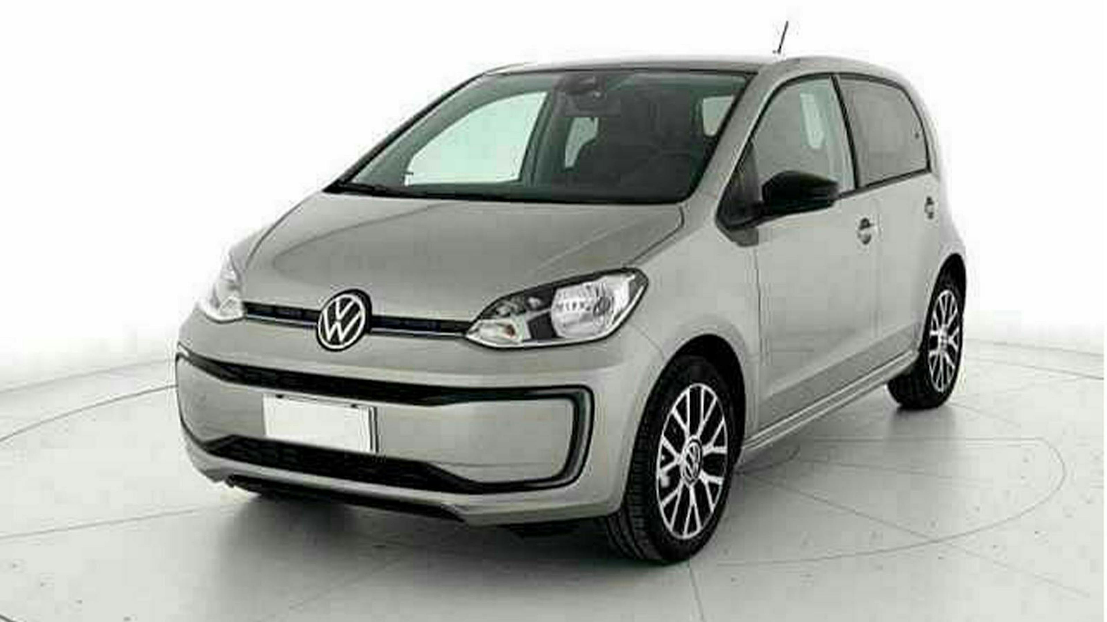 Ein grauer VW e-Up steht in einem weißen Raum mit grauem Boden.