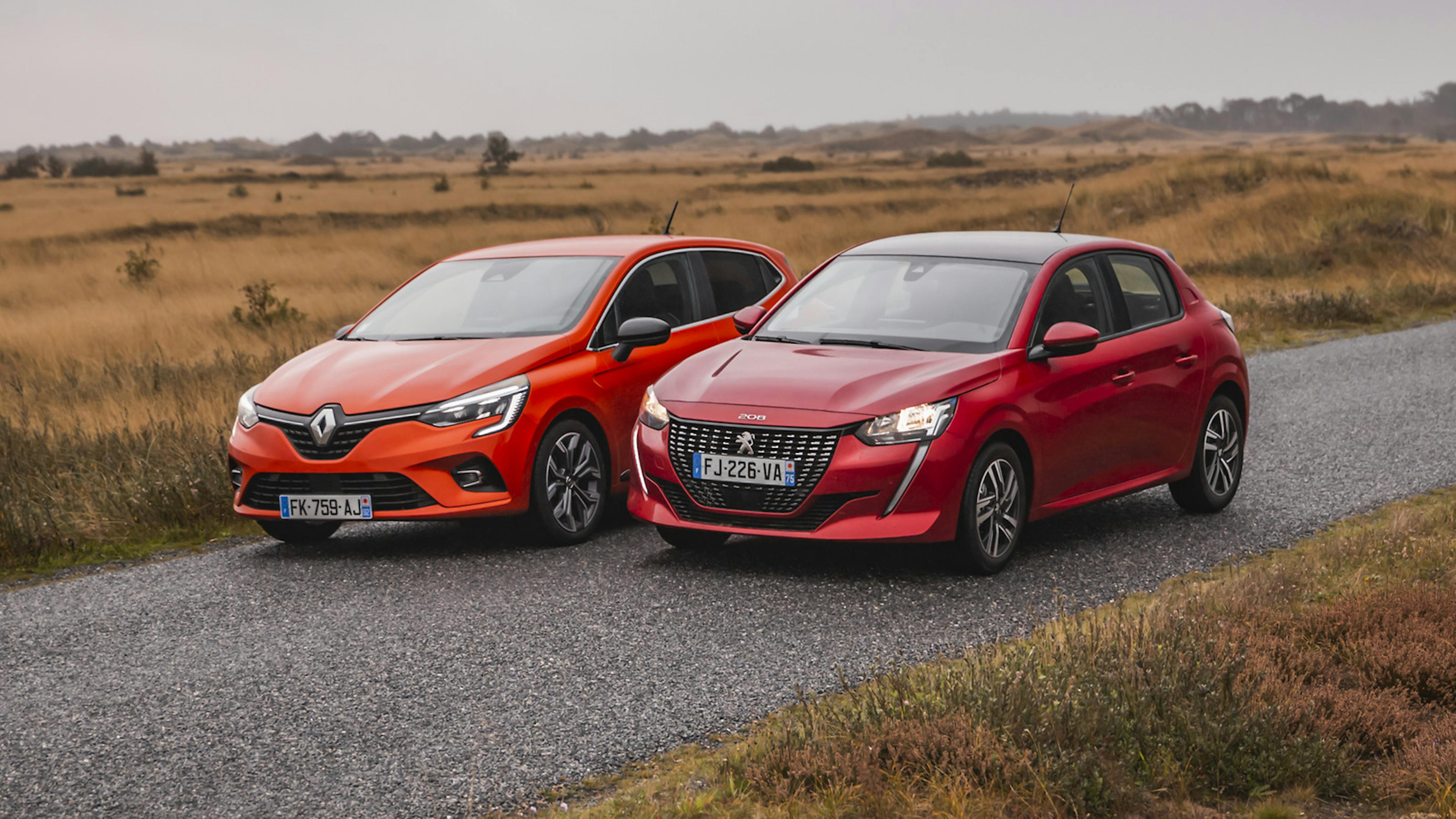 Peugeot 208 und Renault Clio nebeneinander stehend auf einer Landstraße
