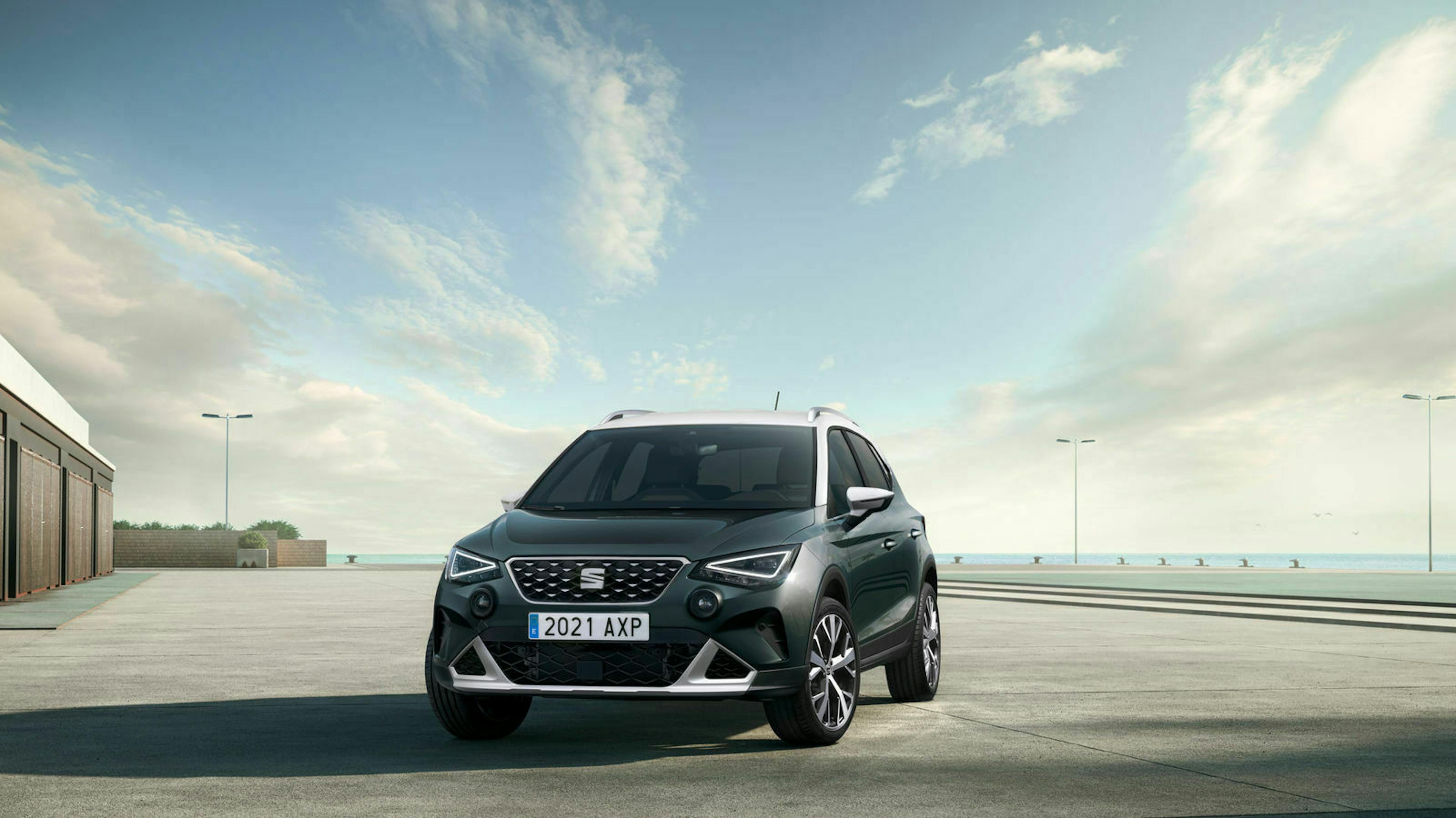 Ein schwarzer Seat Arona steht auf einem leeren Platz, im Hintergrund erkennt man ein Ufer