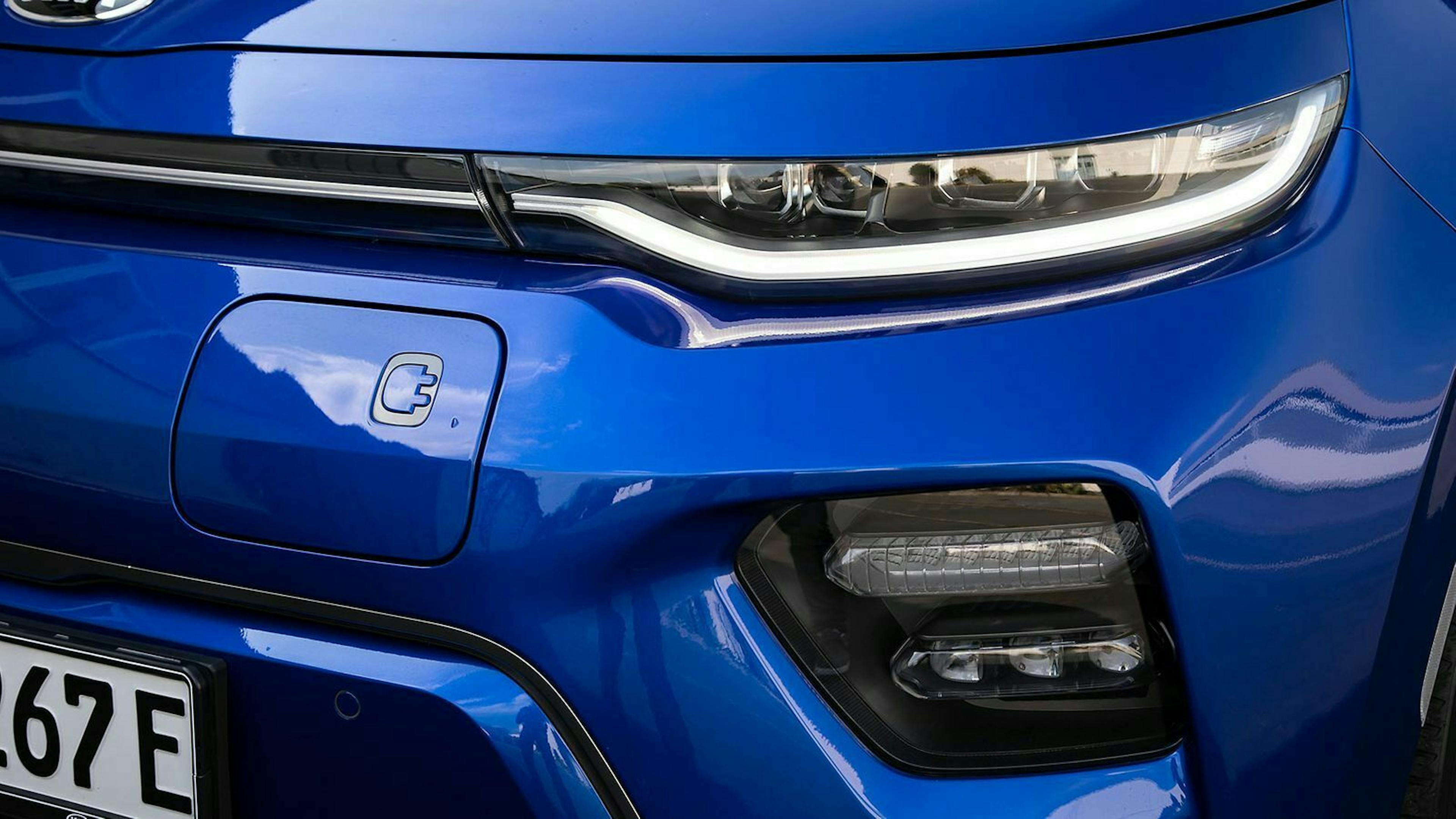 Die Ladeklappe eines blauen Kia e-Soul in der Detail-Aufnahme
