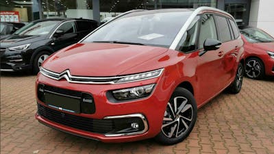 Ein roter Citroën C4 Spacetourer steht auf dem Hof eines Autohauses. Im Hintergrund sind weitere PKW zu sehen