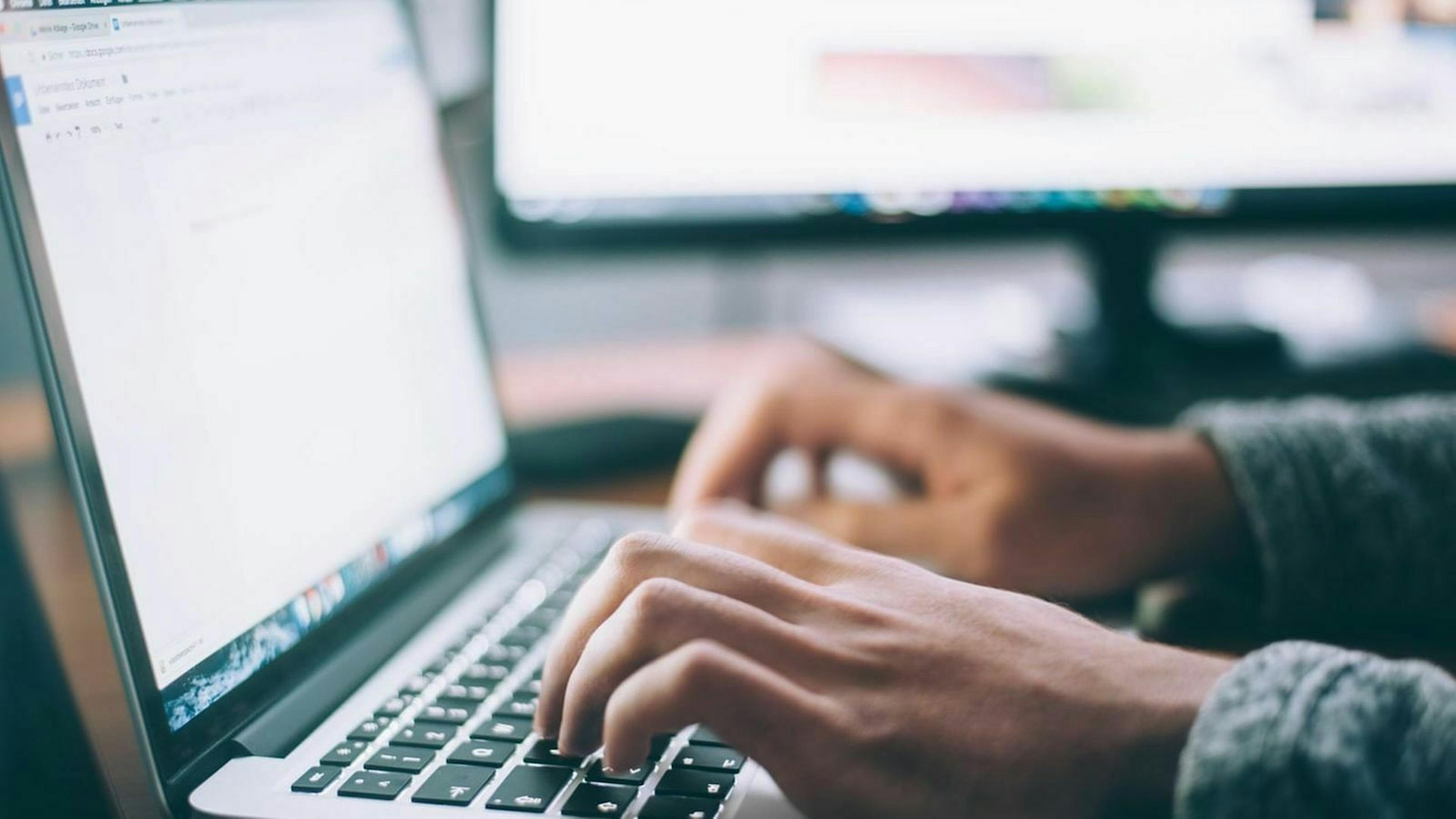 Zu sehen ist ein Mann an einem Laptop