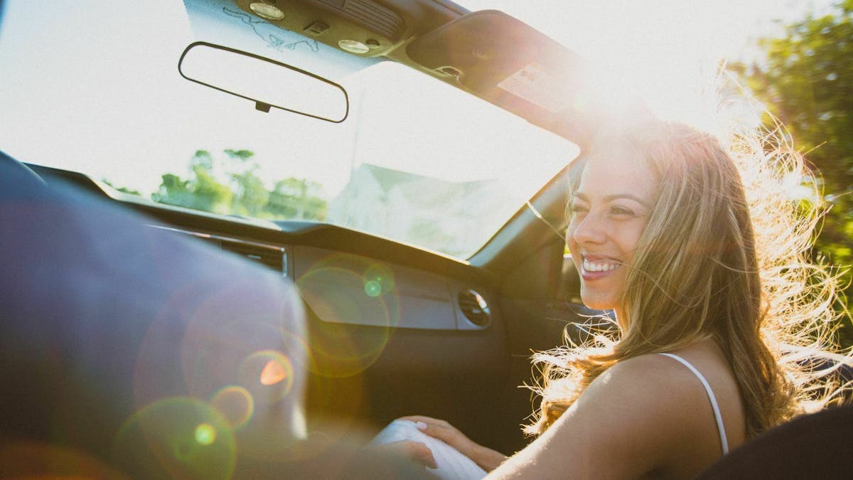 lächelnde Frau im Cabrio