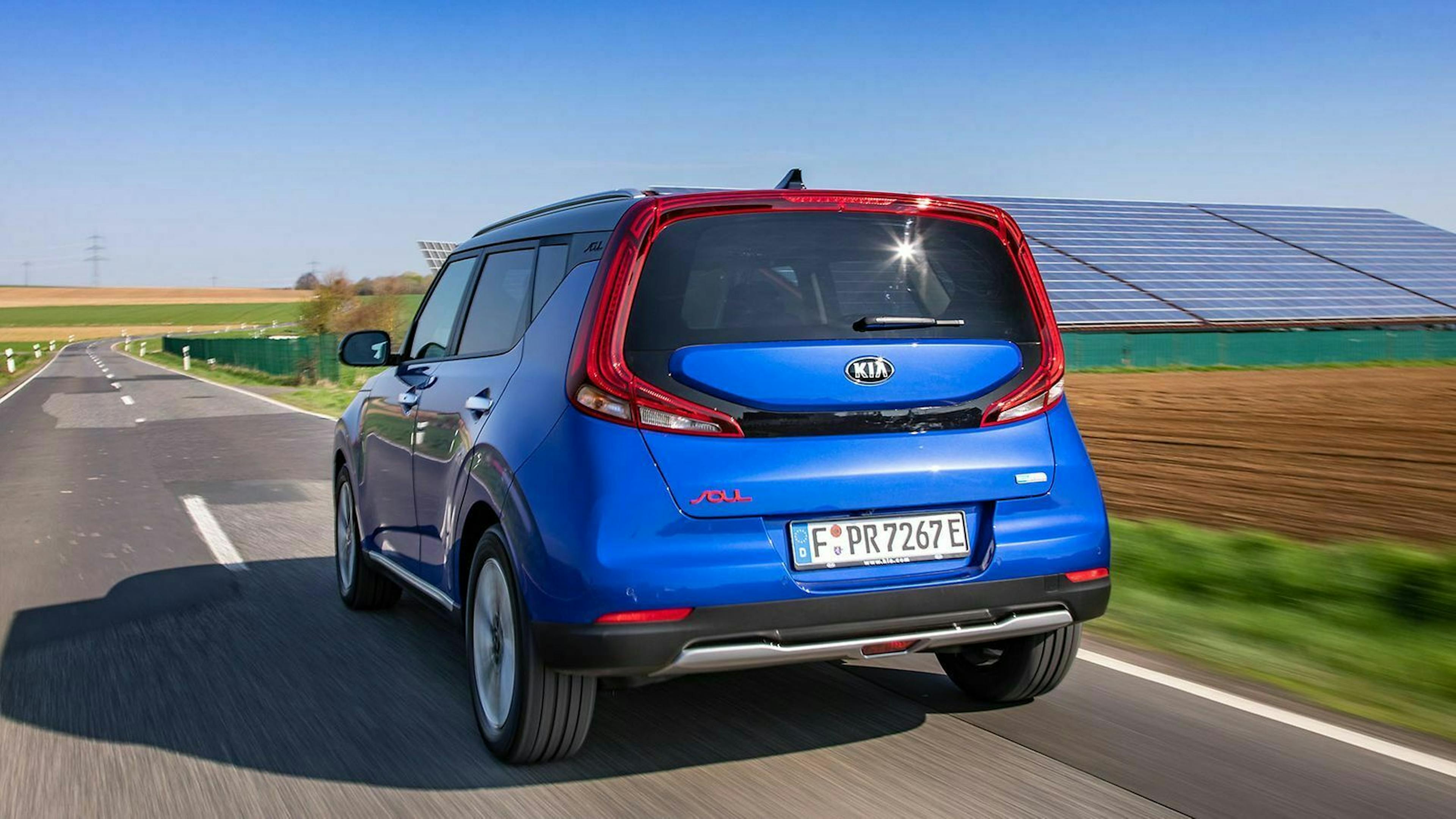 Ein blauer Kia e-Soul auf der Landstraße - Heckansicht