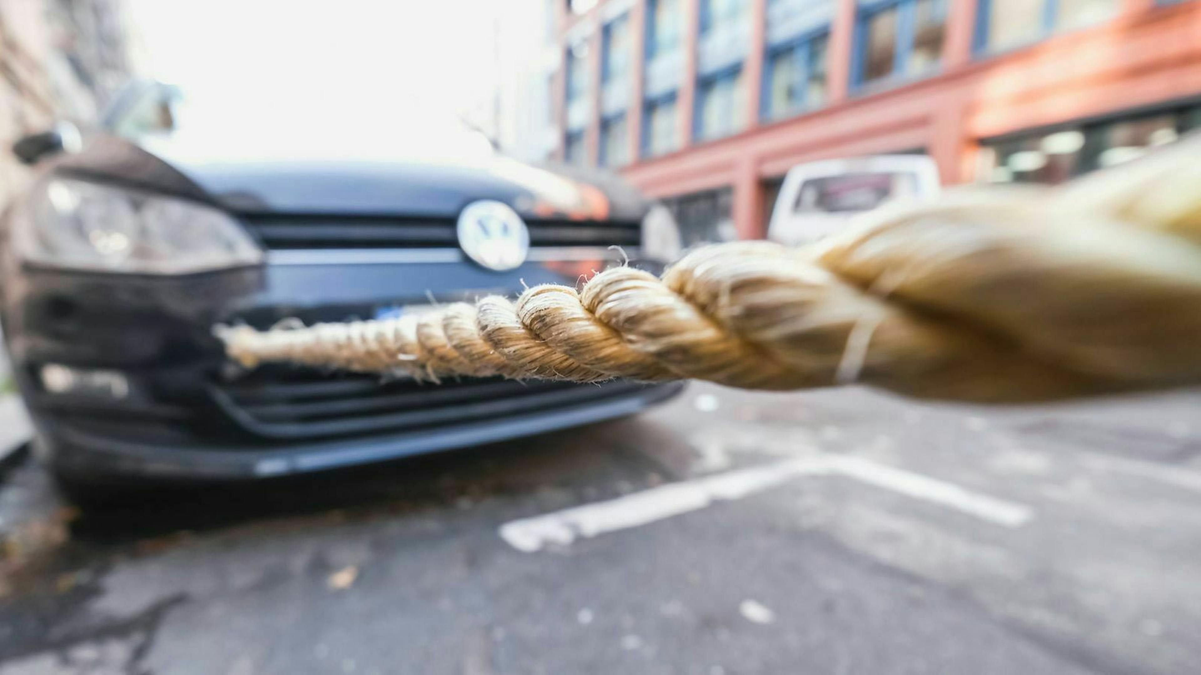 Ein Abschleppseil ist an einem VW Golf befestigt, der gerade abgeschleppt werden soll.