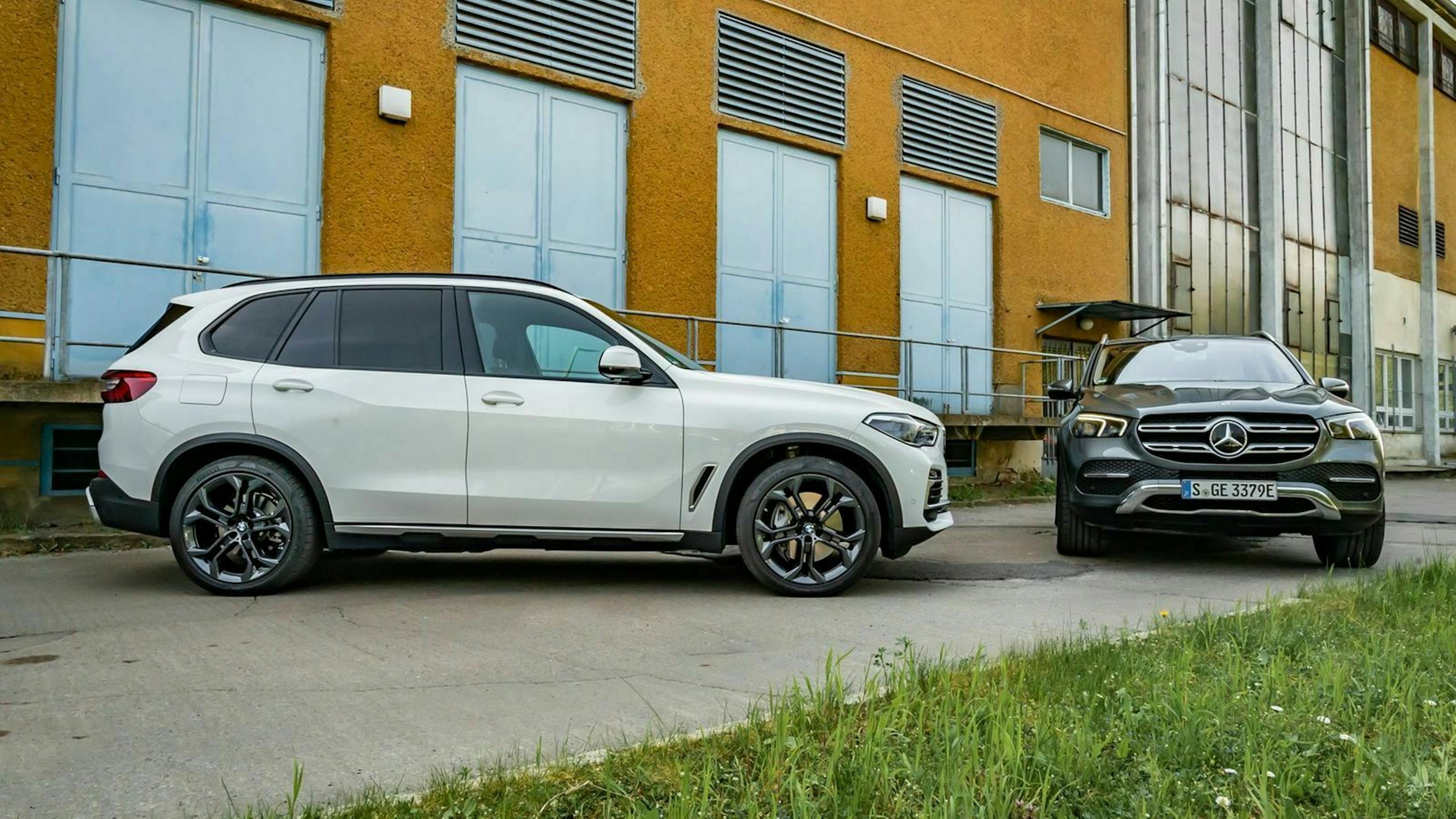 Zu sehen sind der BMW X5 (links, in seitlicher Position) und der Mercedes GLE (rechts, von vorne)