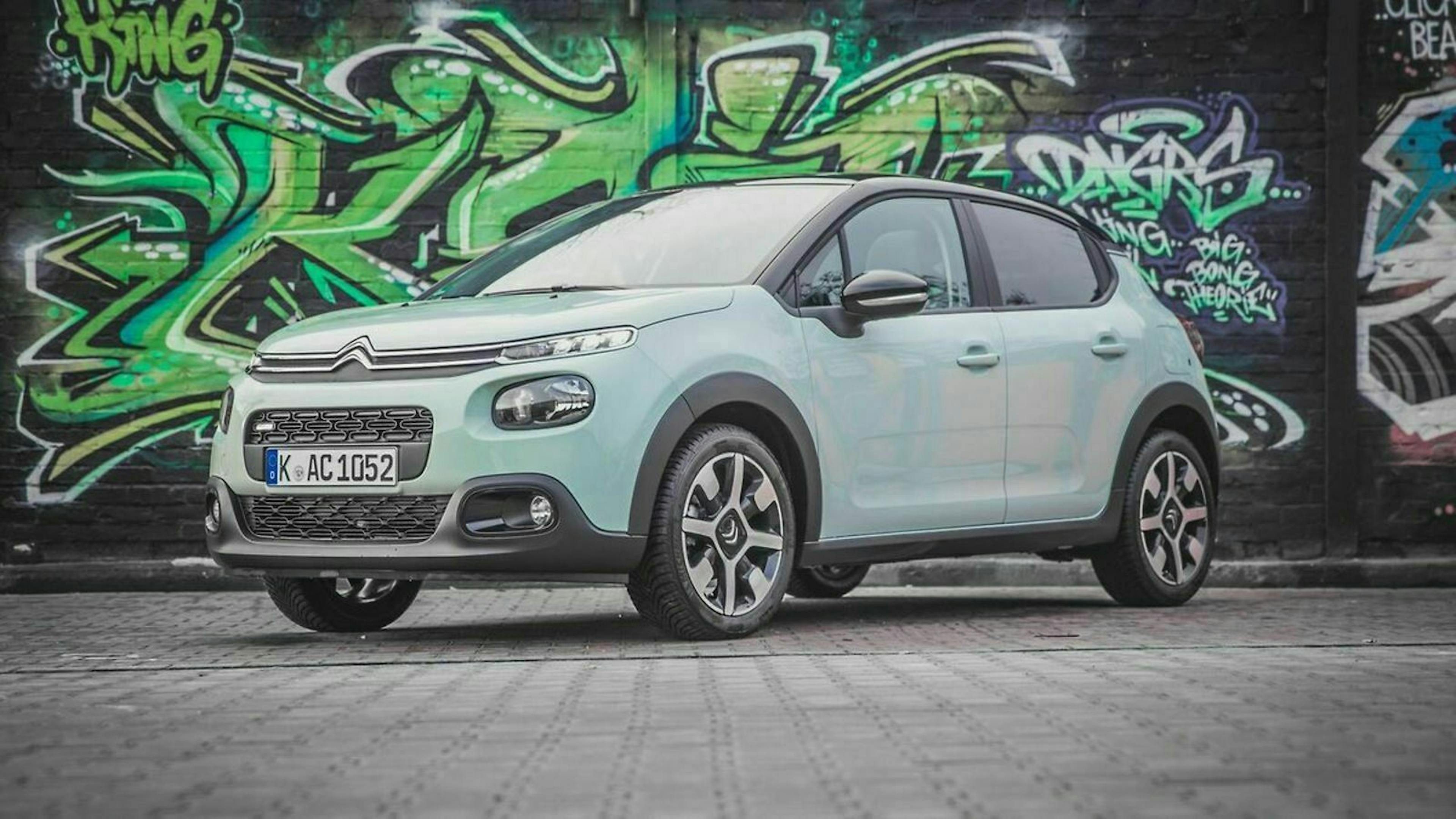 Ein Citroen C3 steht vor einer Wand mit Graffiti.