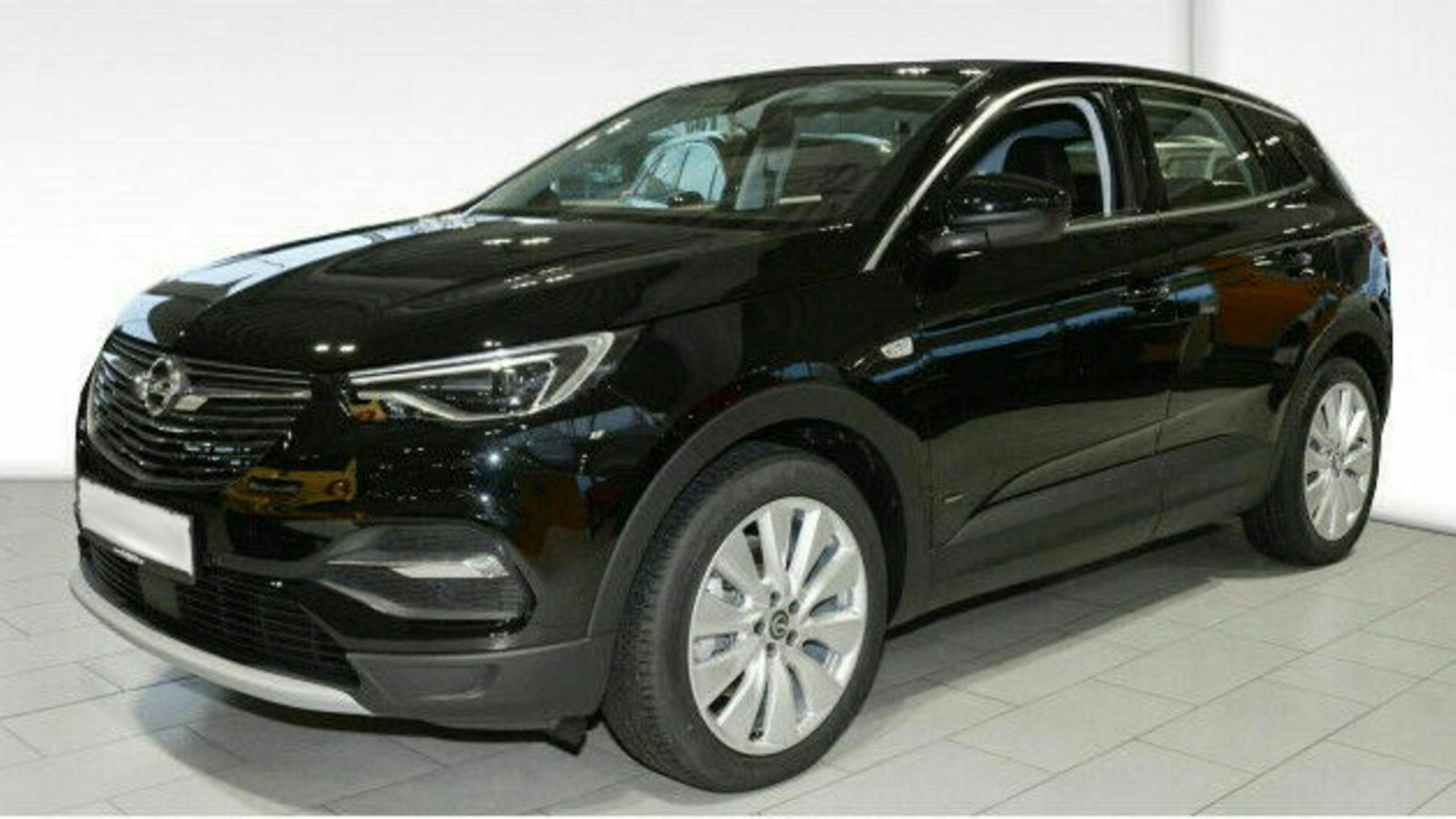Schwarzer SUV der Marke Opel Grandland, seitlich von vorne fotografiert. Das Auto steht auf einem hellen Fliesenboden in einem Studio.