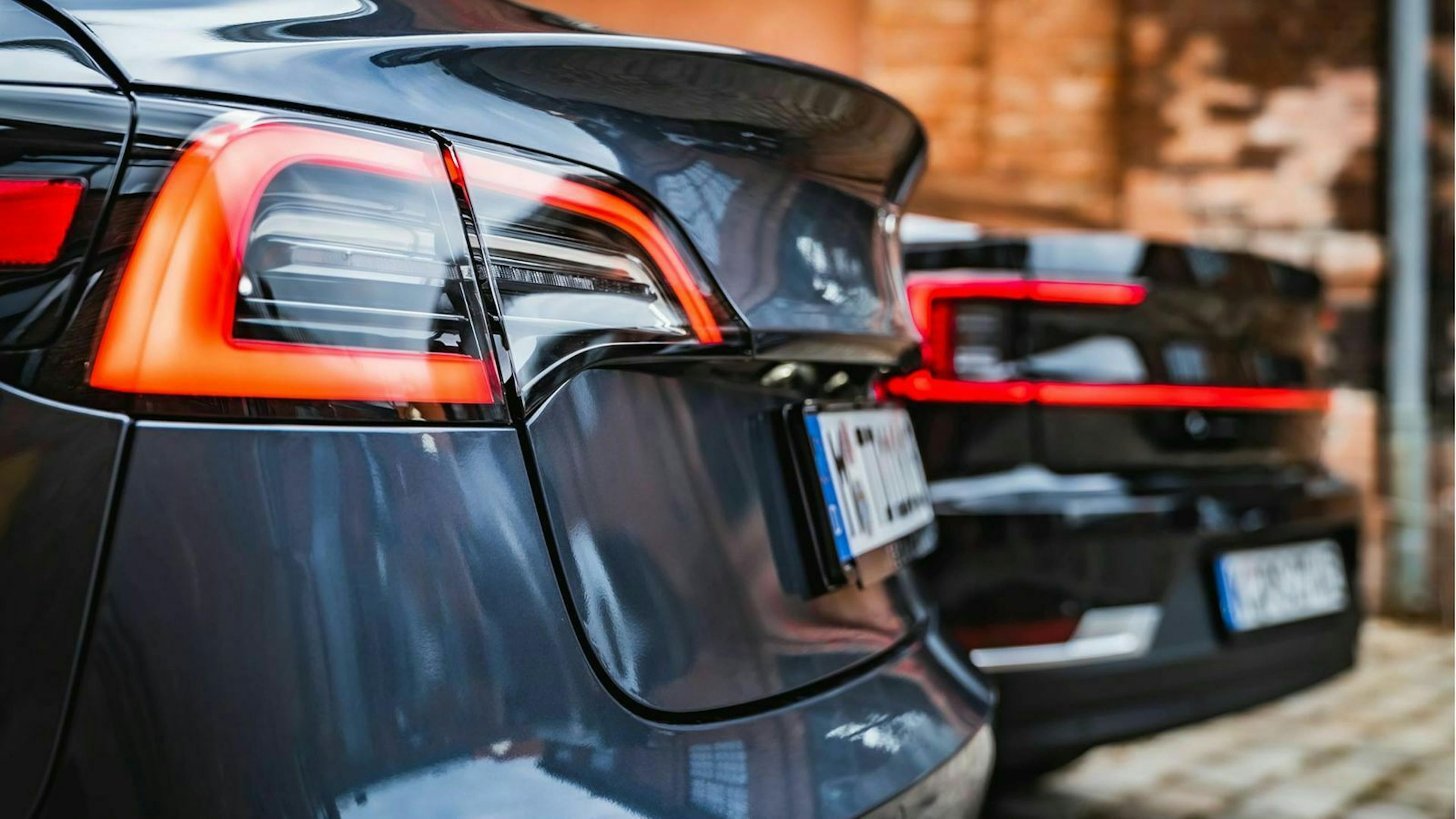 Die Heckleuchten des Polestar 2 und des Tesla Model 3 