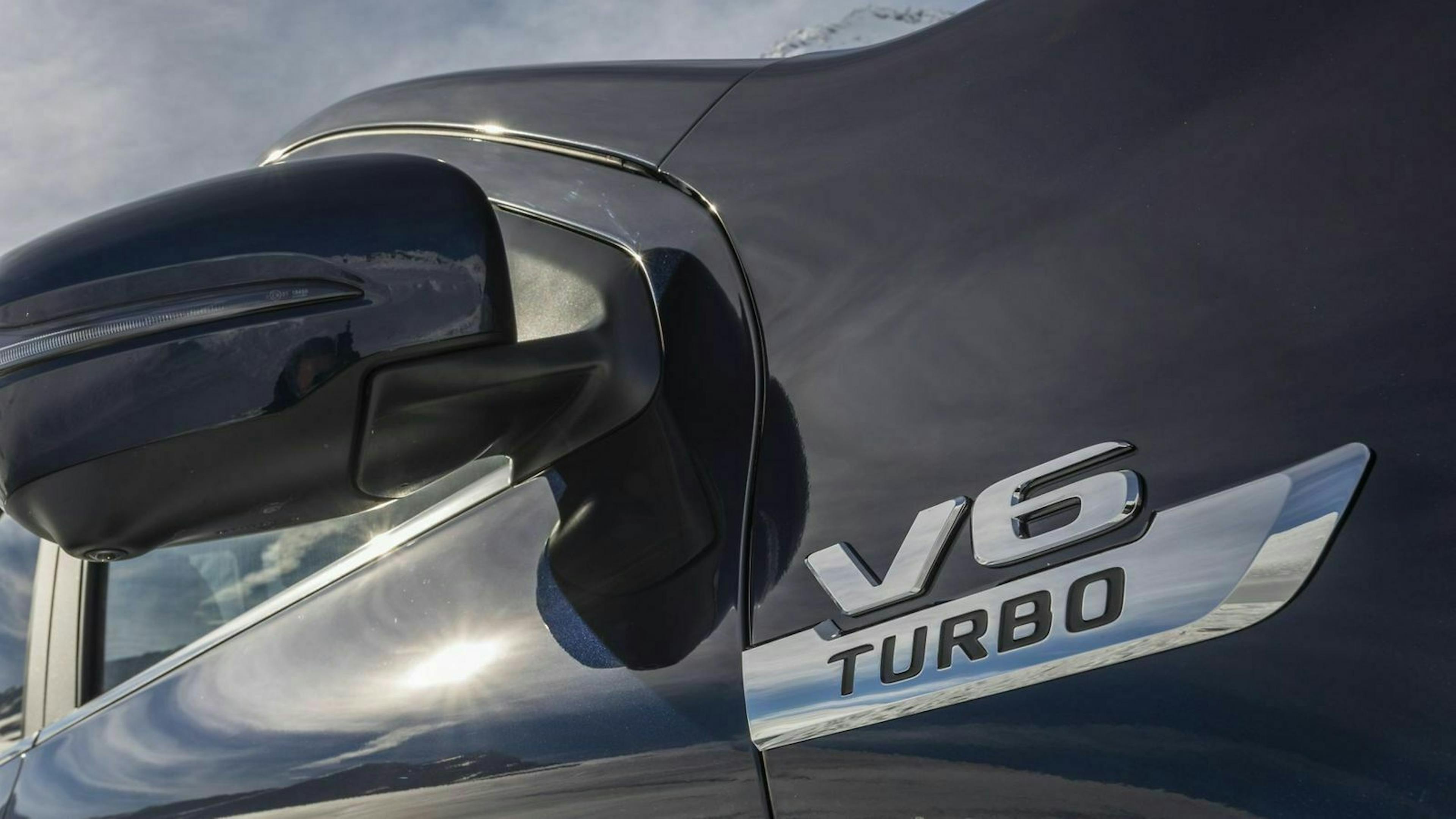 Zu sehen ist ein silberner Schriftzug " V6 Turbo" an der Außenseite der Mercedes X-Klasse