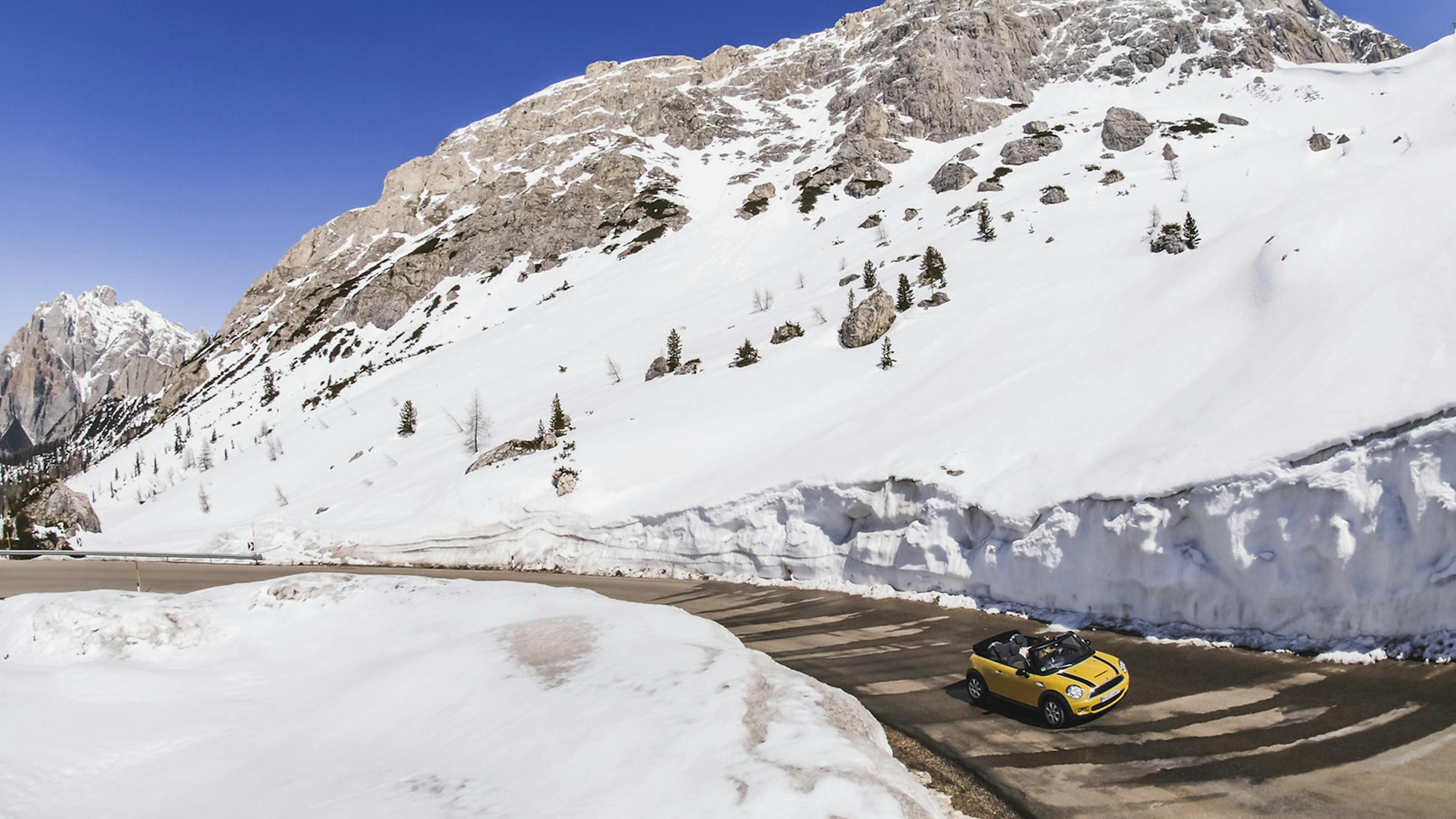 Ein cabrio fährt durch eine Winterlandschaft.