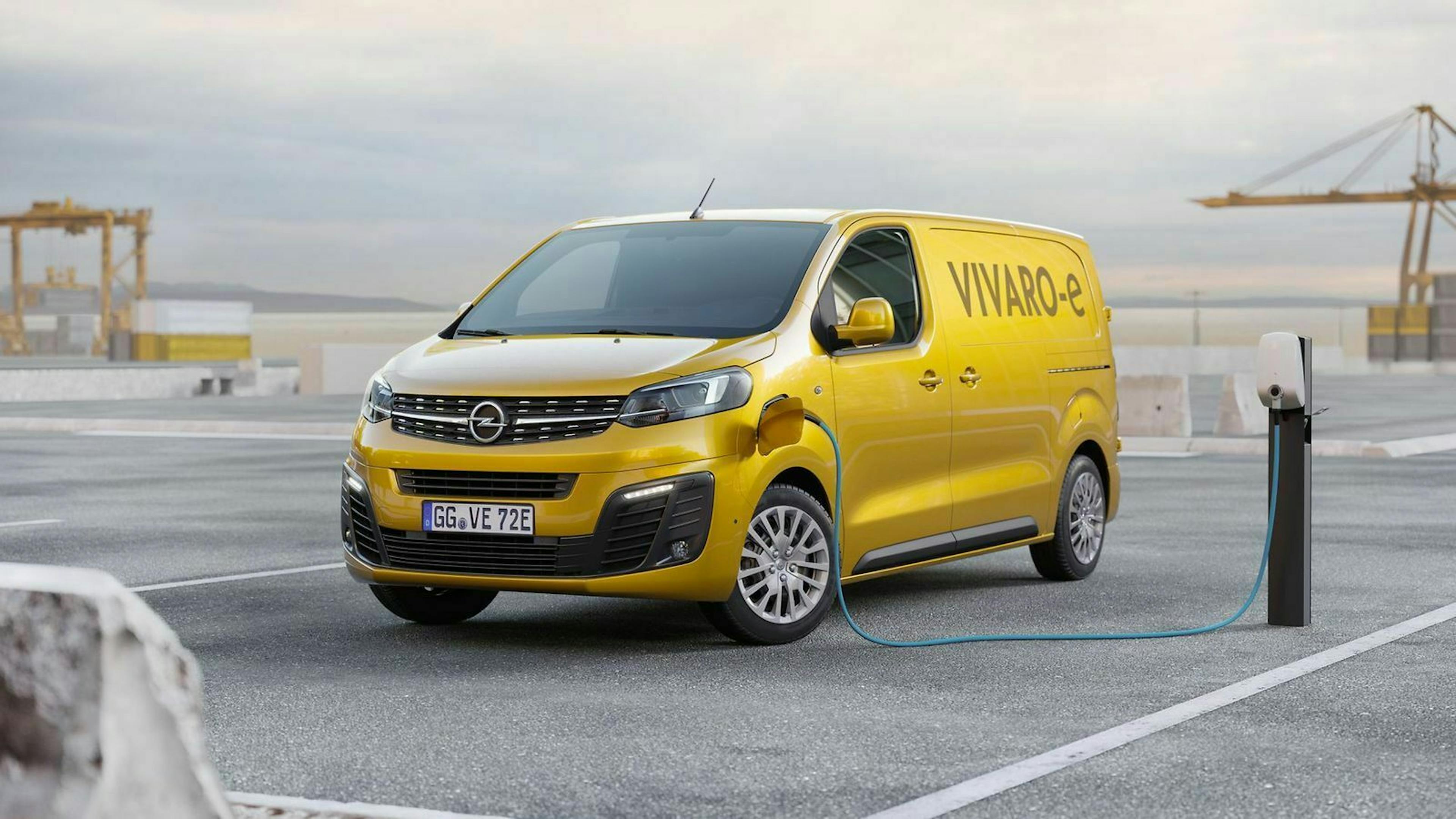 Gelber Vivaro steht neben einer Ladesäule und wird über ein Kabel geladen