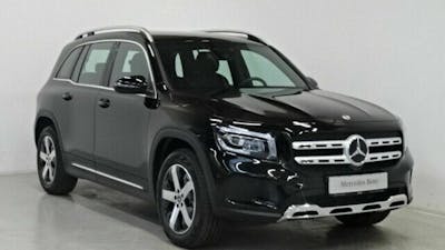Ein schwarzer Mercedes-Benz GLB steht vor einer weißen Wand