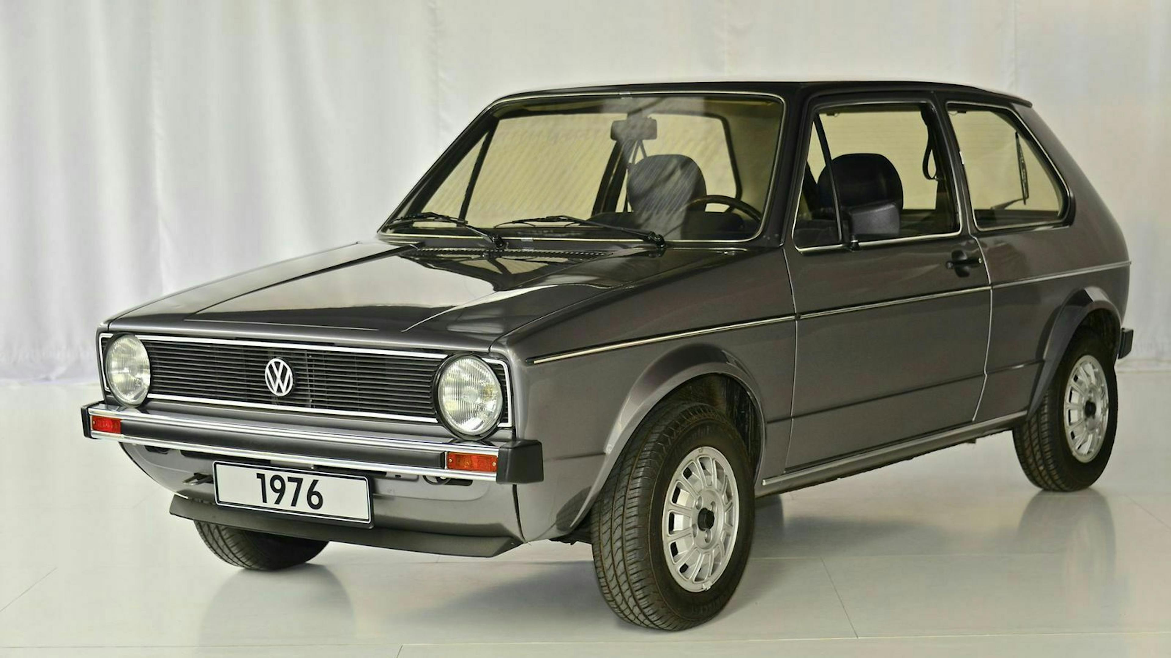 VW Golf 1 in der Ansicht von vorne-links, in einem Showroom stehend