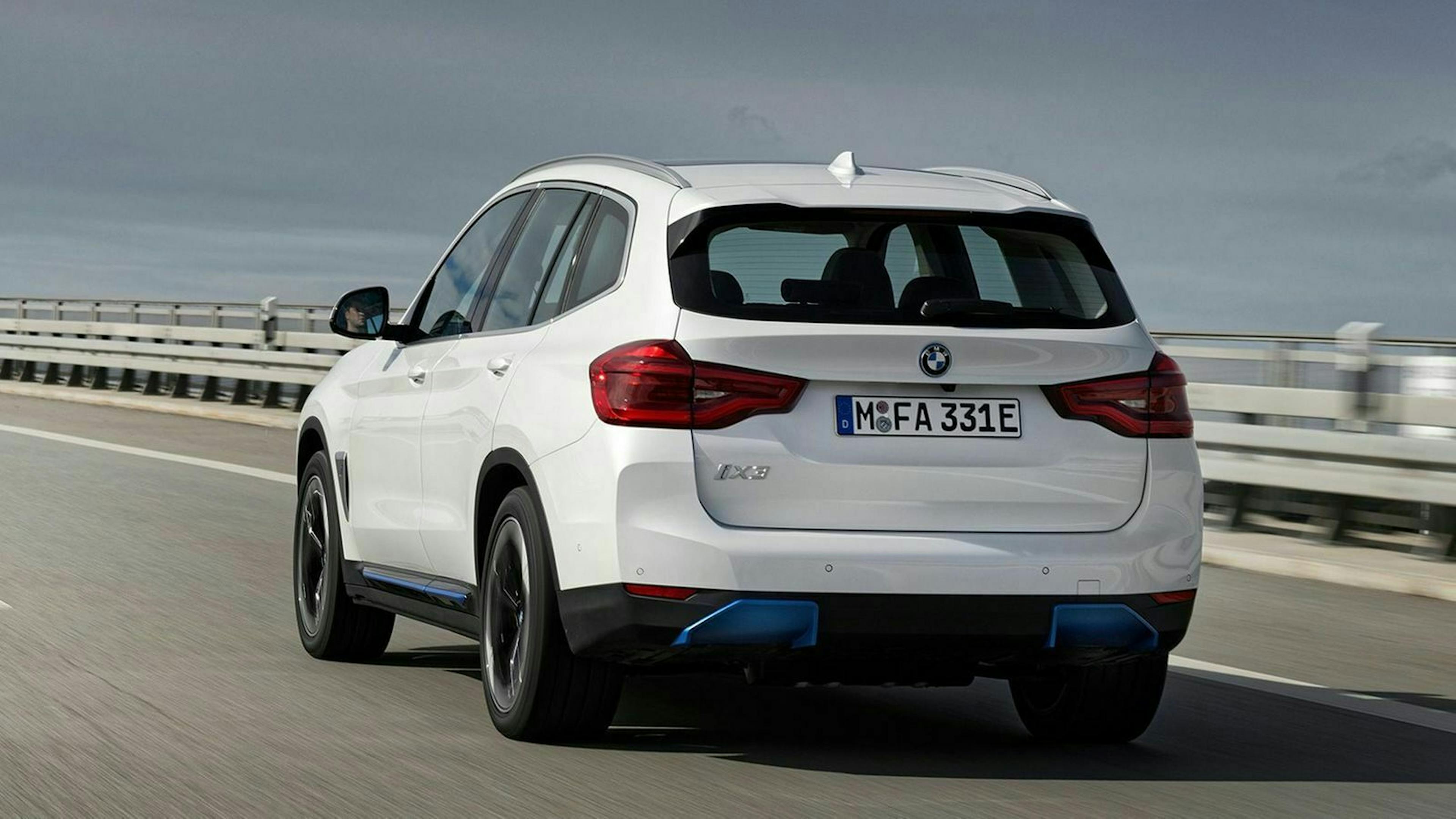 Zu sehen ist der BMW iX3 von hinten, fahrend