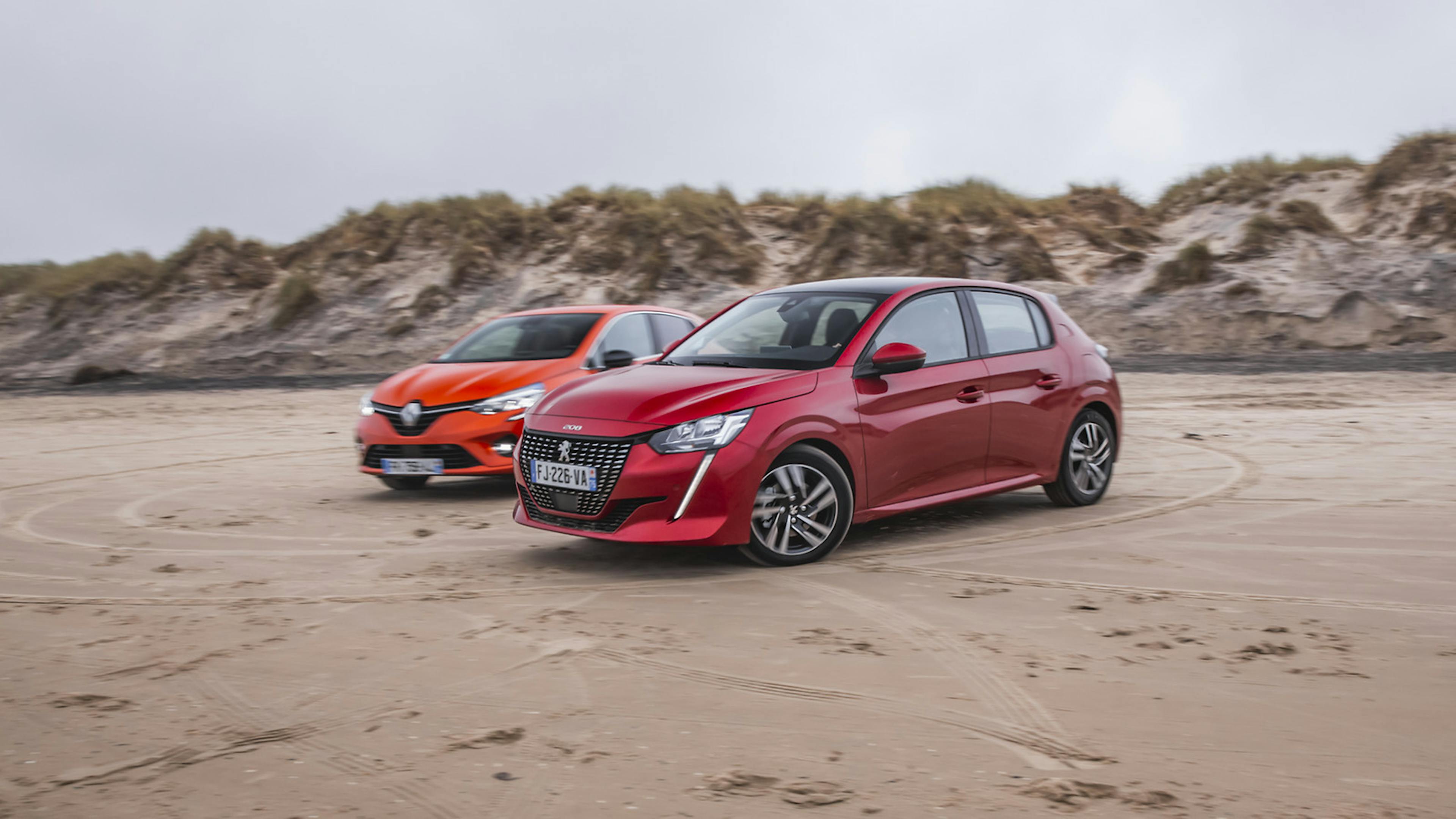Peugeot 208 am Strand stehend vor dem Renault Clio