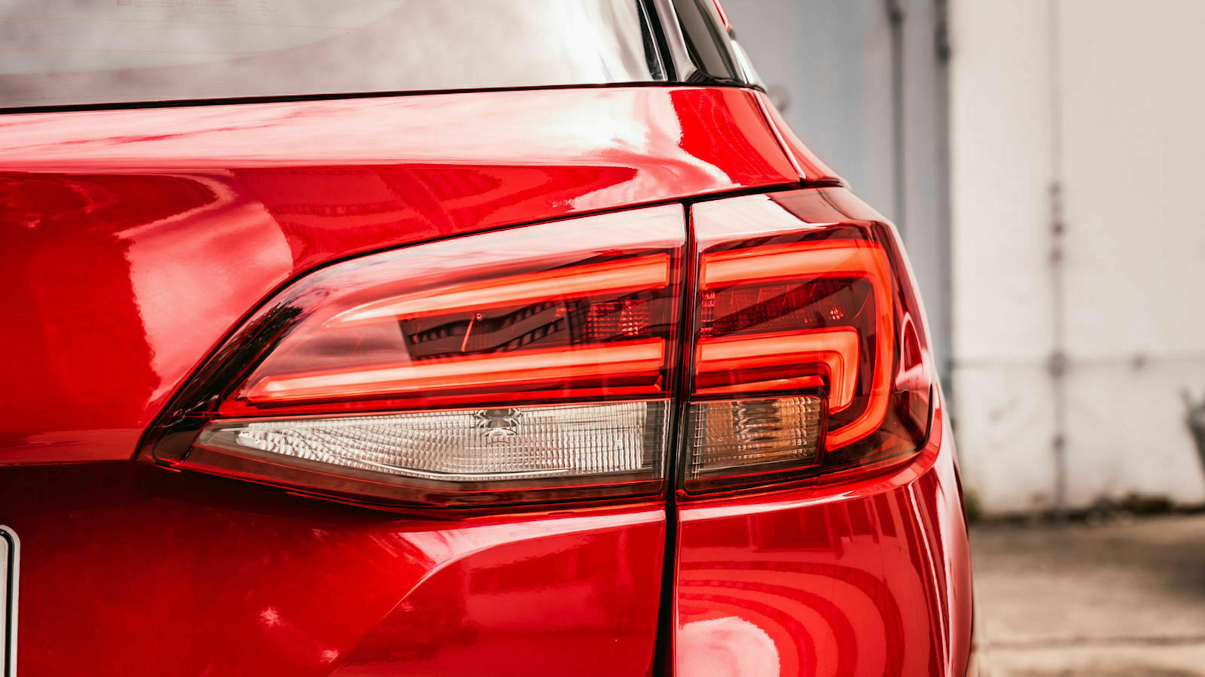 Rotes Auto-Heck mit modernem, leuchtendem Rücklichtdesign in Nahaufnahme.