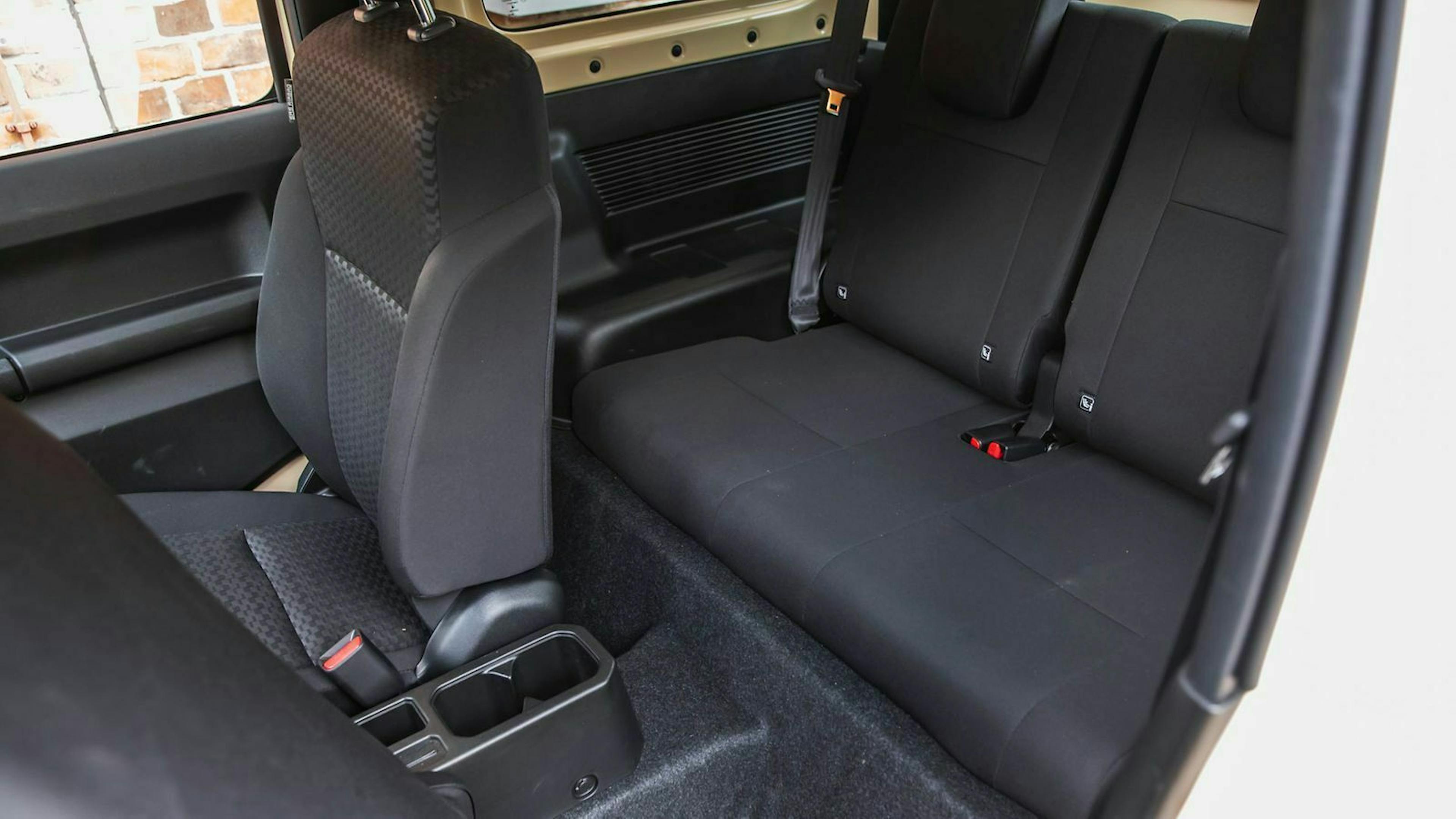 Kurze Sitzflächen mit dünnen Polstern im Innenraum des Suzuki Jimny
