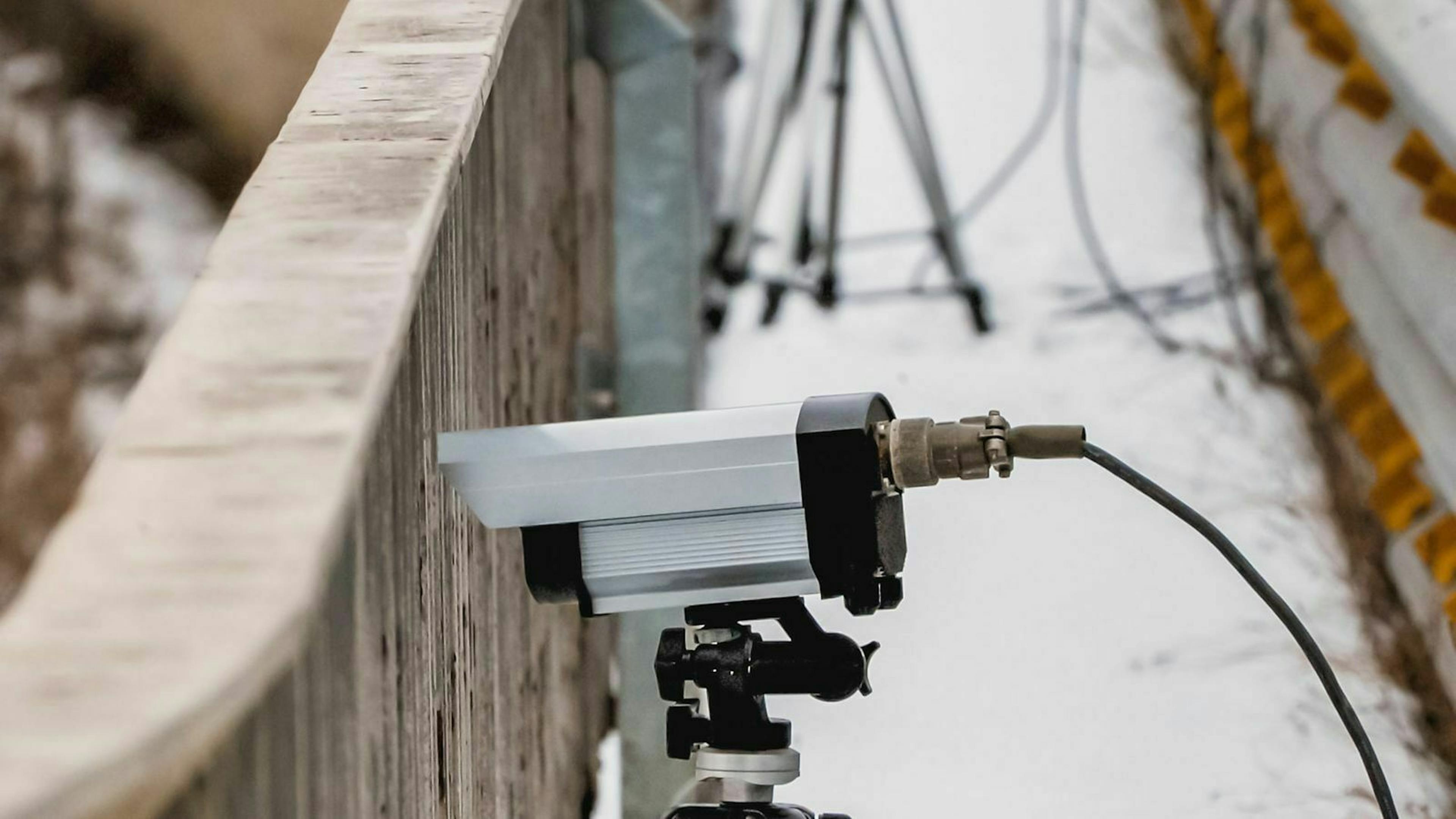 Ein Lasermessgerät steht auf eine Autobahnbrücke.